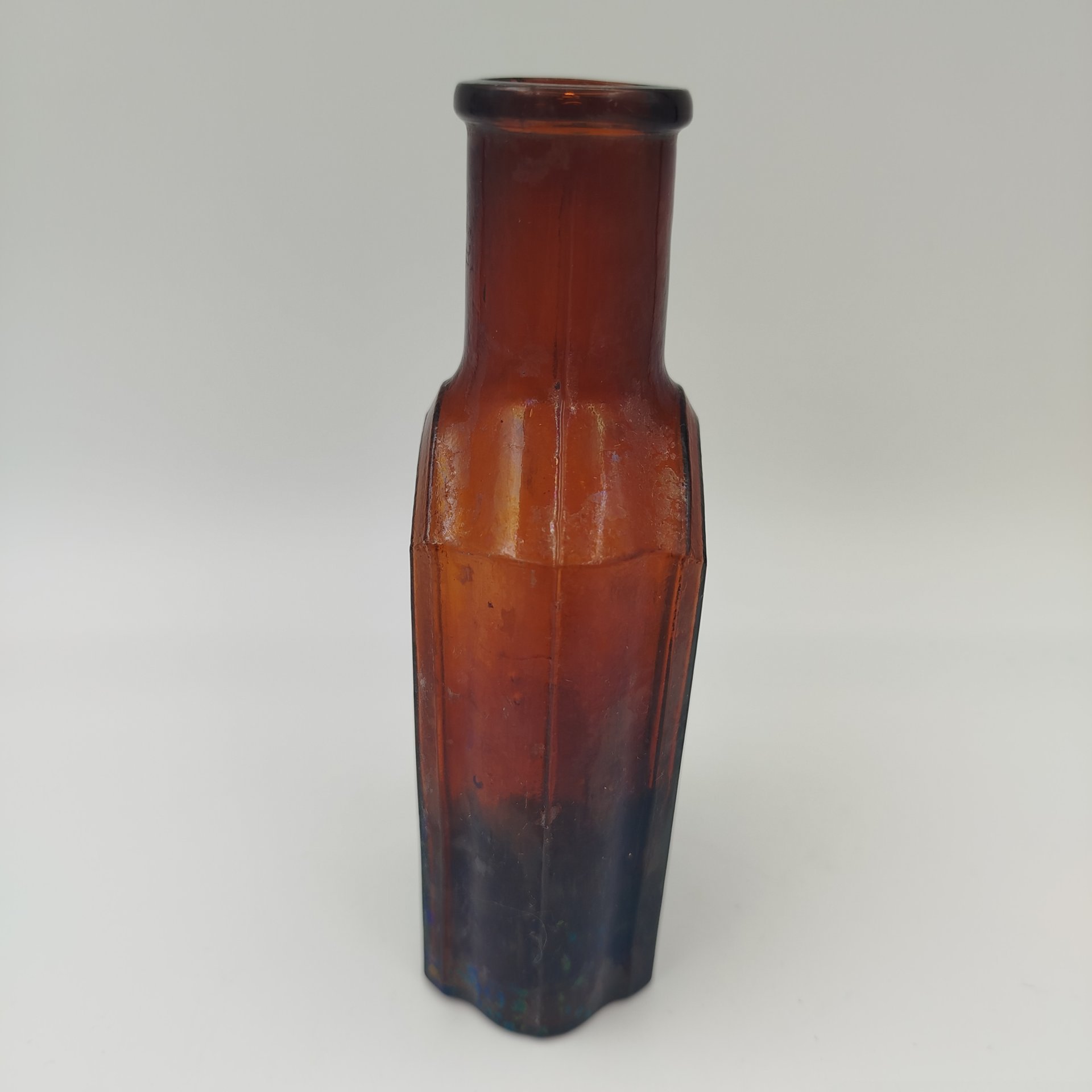 Флакон коричневого цвета с уплощенным туловом