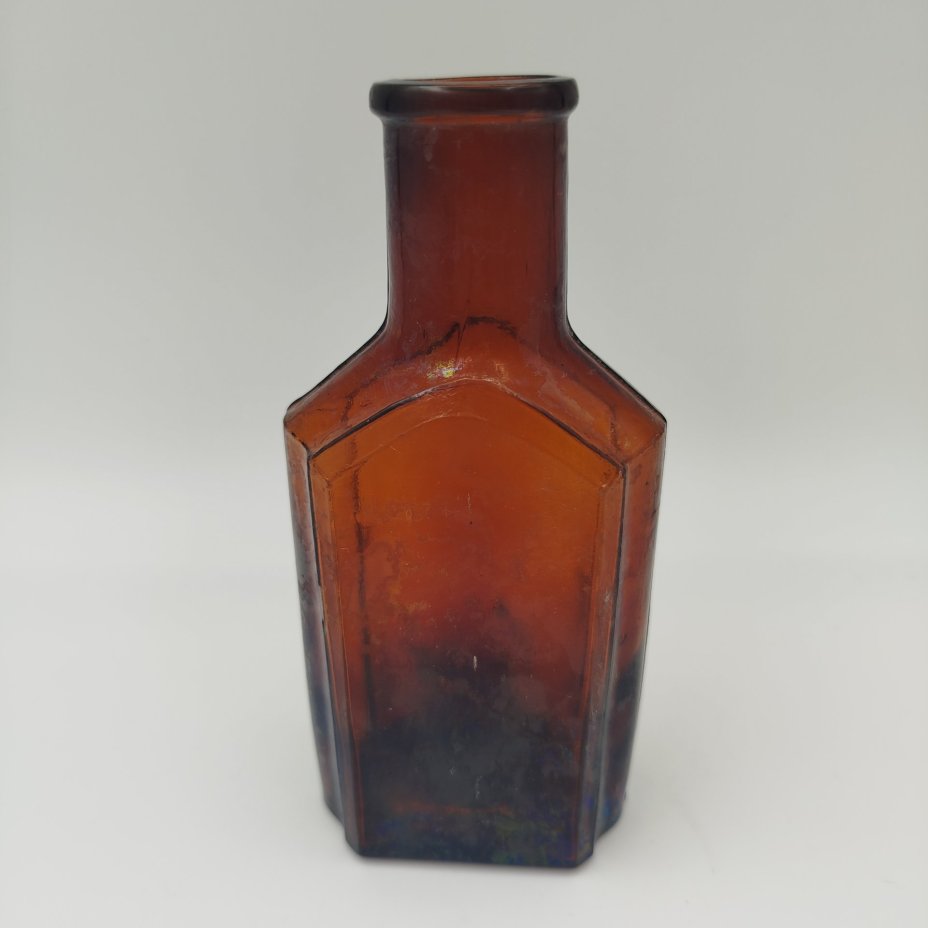 Флакон коричневого цвета с уплощенным туловом