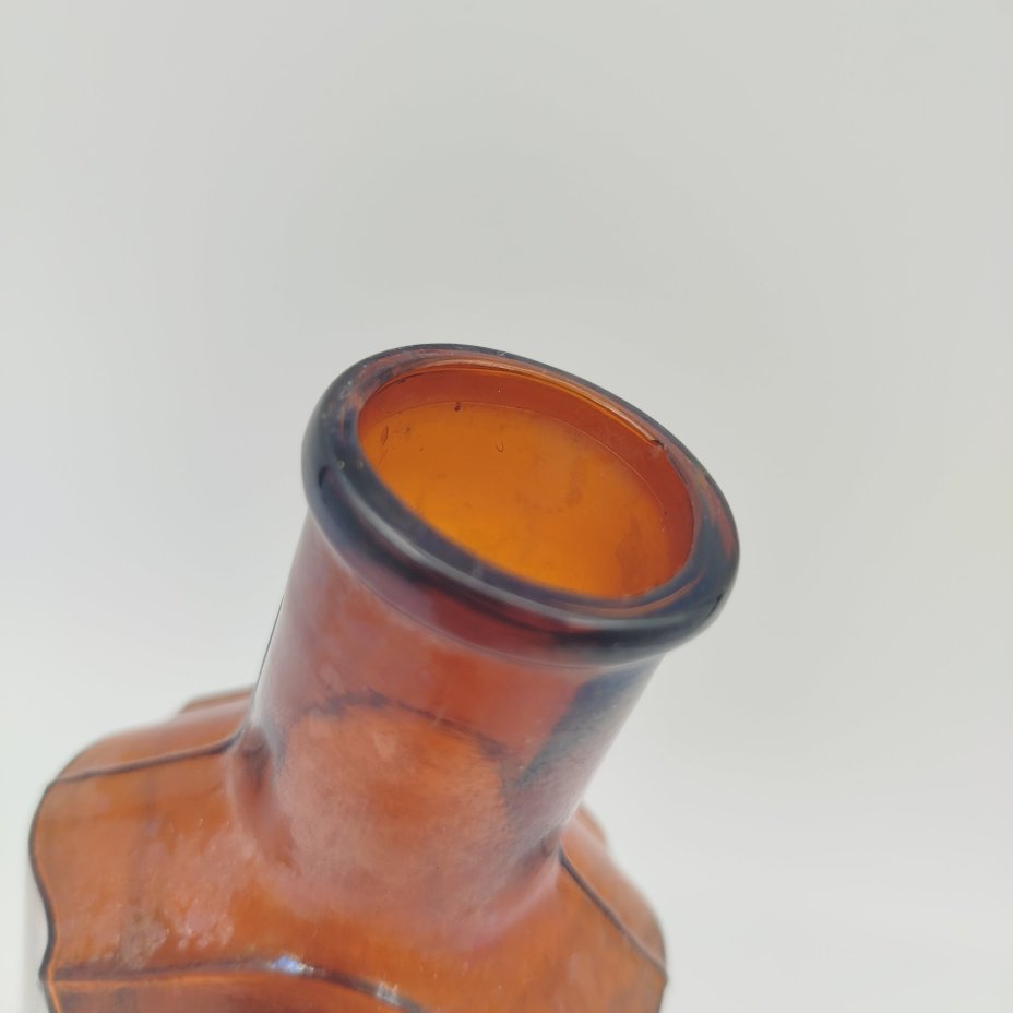 Флакон коричневого цвета с уплощенным туловом