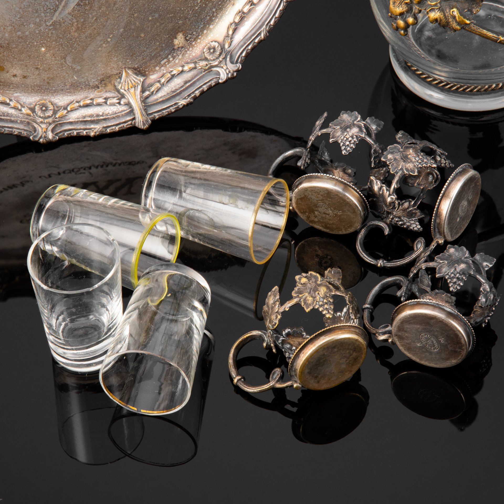 Набор для крепких напитков, состоящий из подноса, графина и четырех стопок на подставках, с растительным декором и дарственной надписью "Въ память отъ любящихъ дѣтей XXV" и "1883.20.10/1908", стекло, металл, серебрение, Plewkiewicz & Co. (Фабрика Романа Плевкевича), Царство Польское, 1908 г.