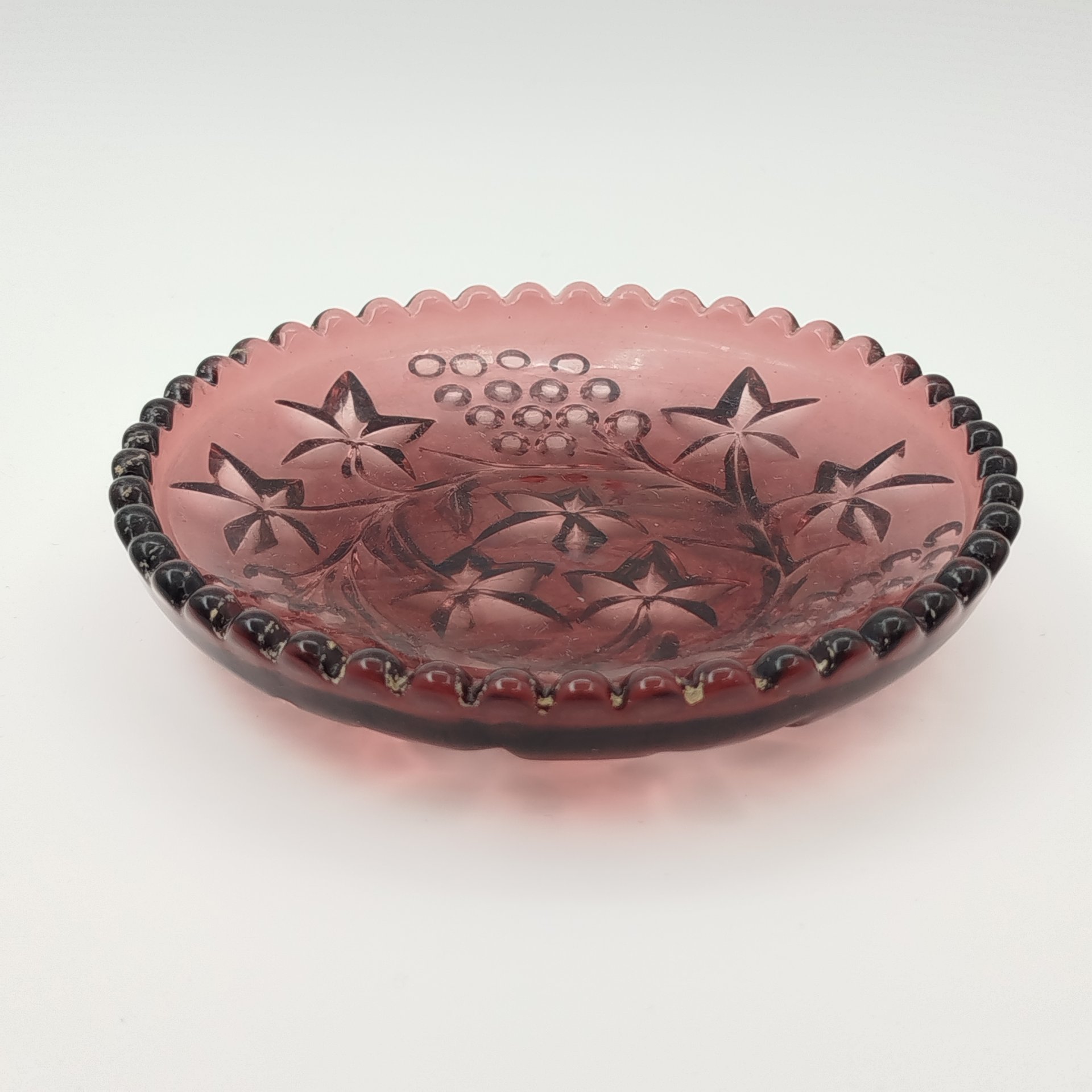 Тарелочка марганцевого цвета с декором в виде виноградных лоз, выполненным с оборотной стороны, марганцевое стекло, литье, Россия, 1900-1940 гг.