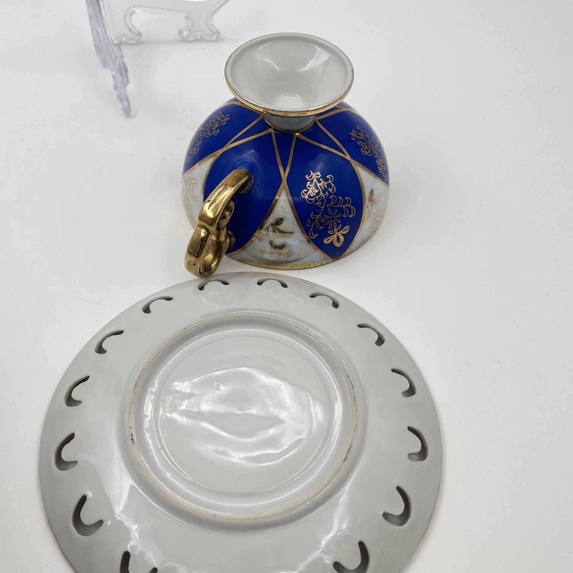 Чайная пара, украшенная изображением роз, кобальтовым декором и резным бортиком на блюдце, фарфор, люстр, золочение, деколь, Западная Европа, 1960-1990 гг.