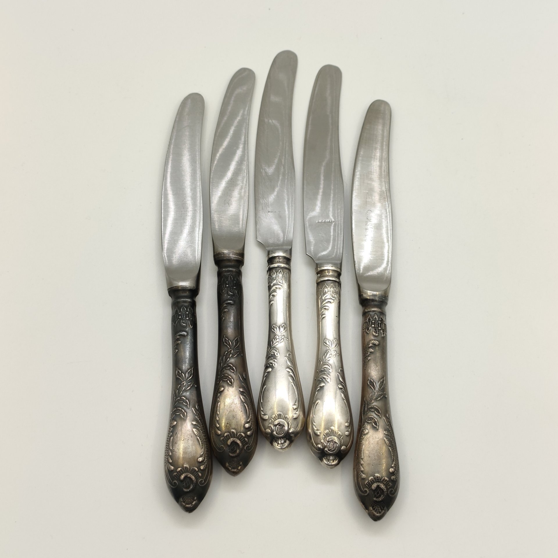 Набор из пяти десертных ножей с растительным декором (в подборе), мНЦ (медь-никель-цинк), нержавеющая сталь, Вольнянский завод столовых приборов им. Шевченко (ЗiШ, ЗиШ), СССР, 1960-1990 гг.