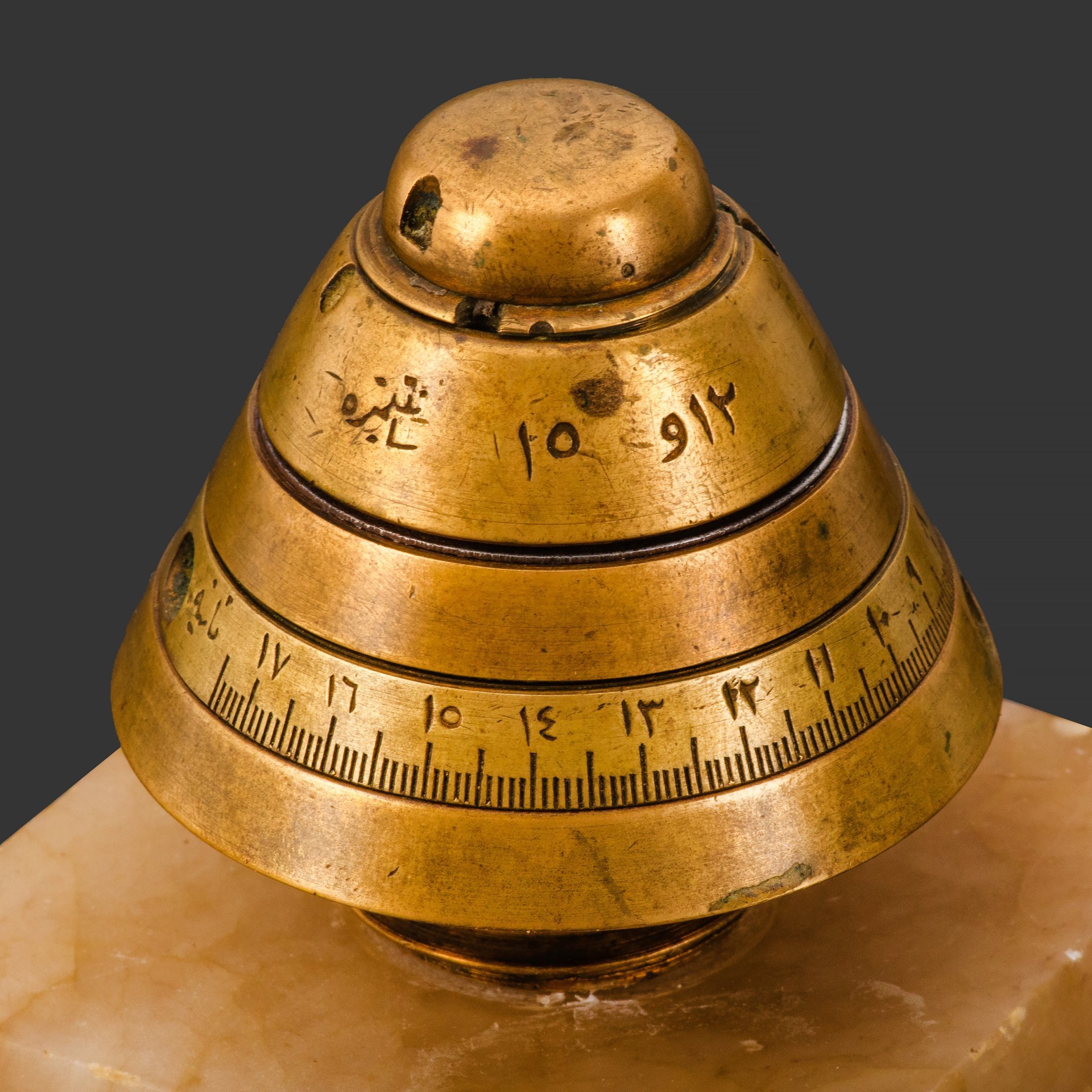 Сувенир настольный (военный), выполненный из головной части дистанционной трубки к шрапнельному снаряду, с обозначениями на арабском языке, бронза, камень, Российская империя, 1890-1915 гг.