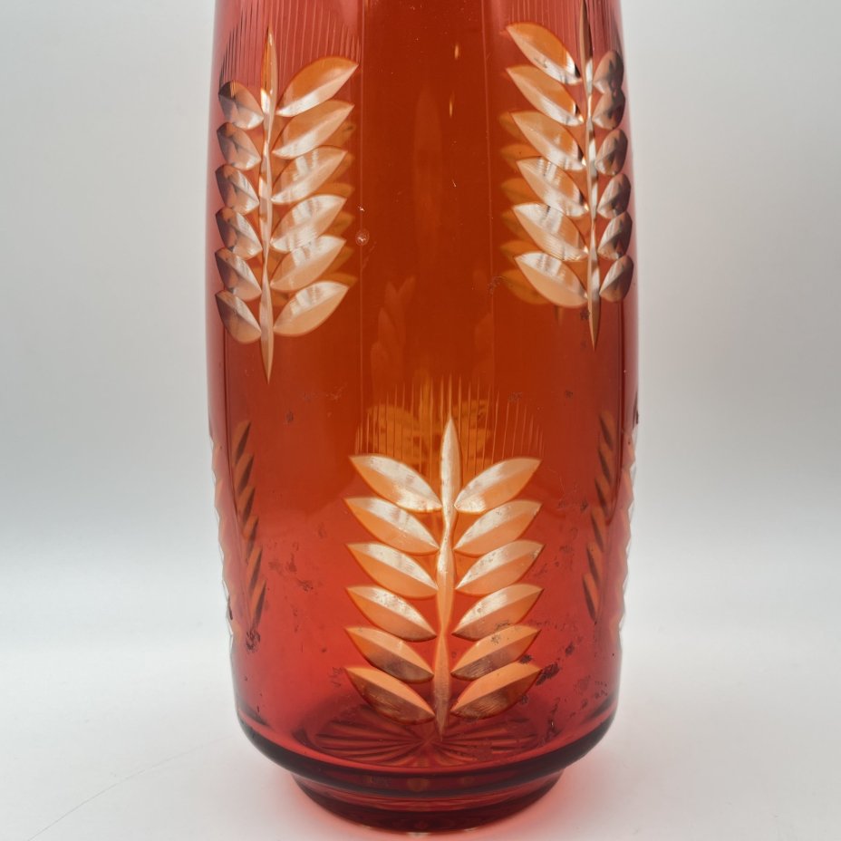 Ваза рубинового оттенка, украшенная растительным декором