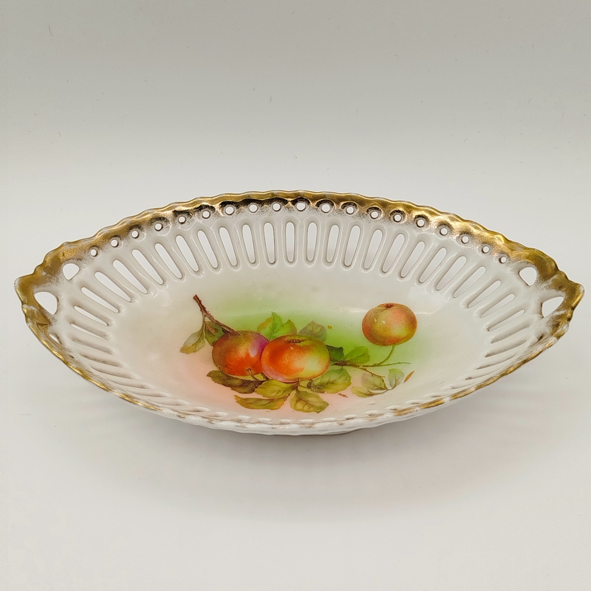 Сухарница овальной формы с прорезным бортом, украшенная изображением яблок, фарфор, деколь, золочение, Западная Европа, 1900-1930 гг.