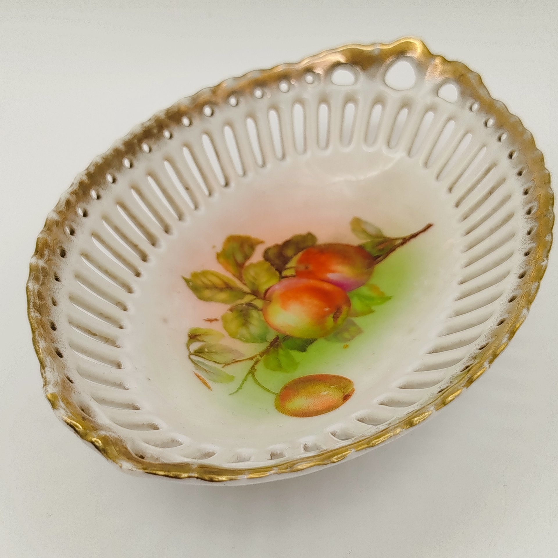 Сухарница овальной формы с прорезным бортом, украшенная изображением яблок, фарфор, деколь, золочение, Западная Европа, 1900-1930 гг.