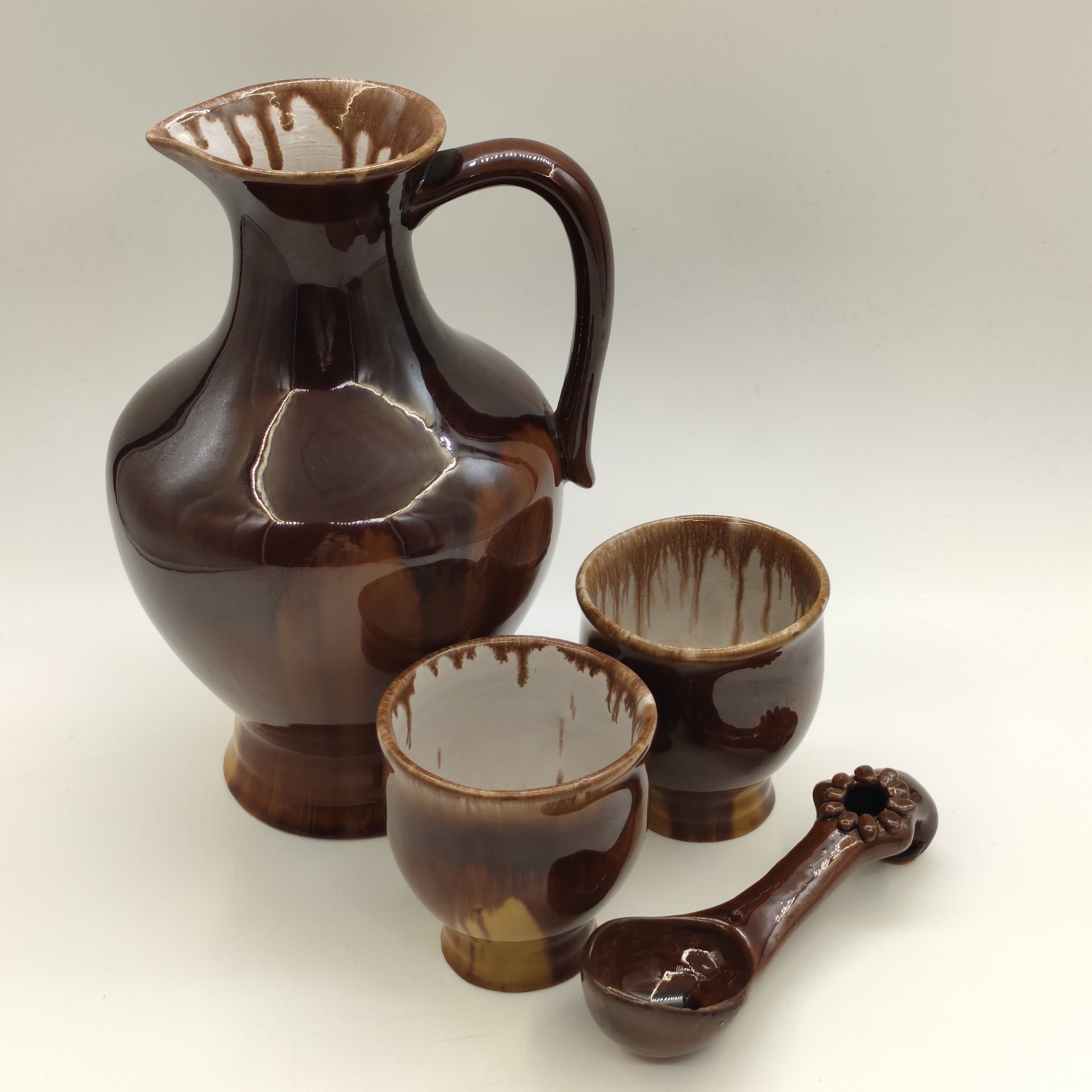 Кувшин с двумя стаканами и ложечкой жёлто-коричневого оттенка