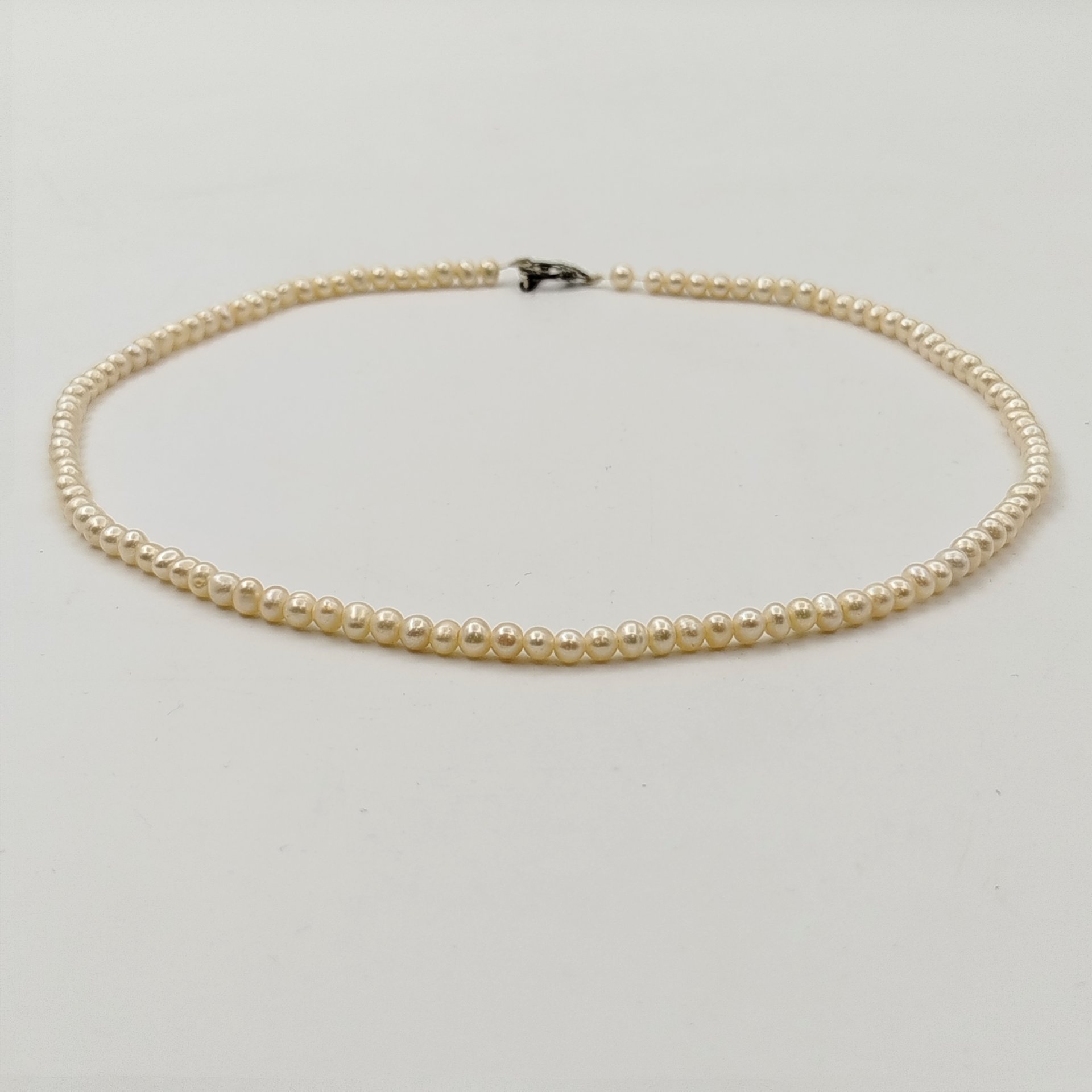 Бусы с мелкими круглыми бусинами и фигурной застежкой