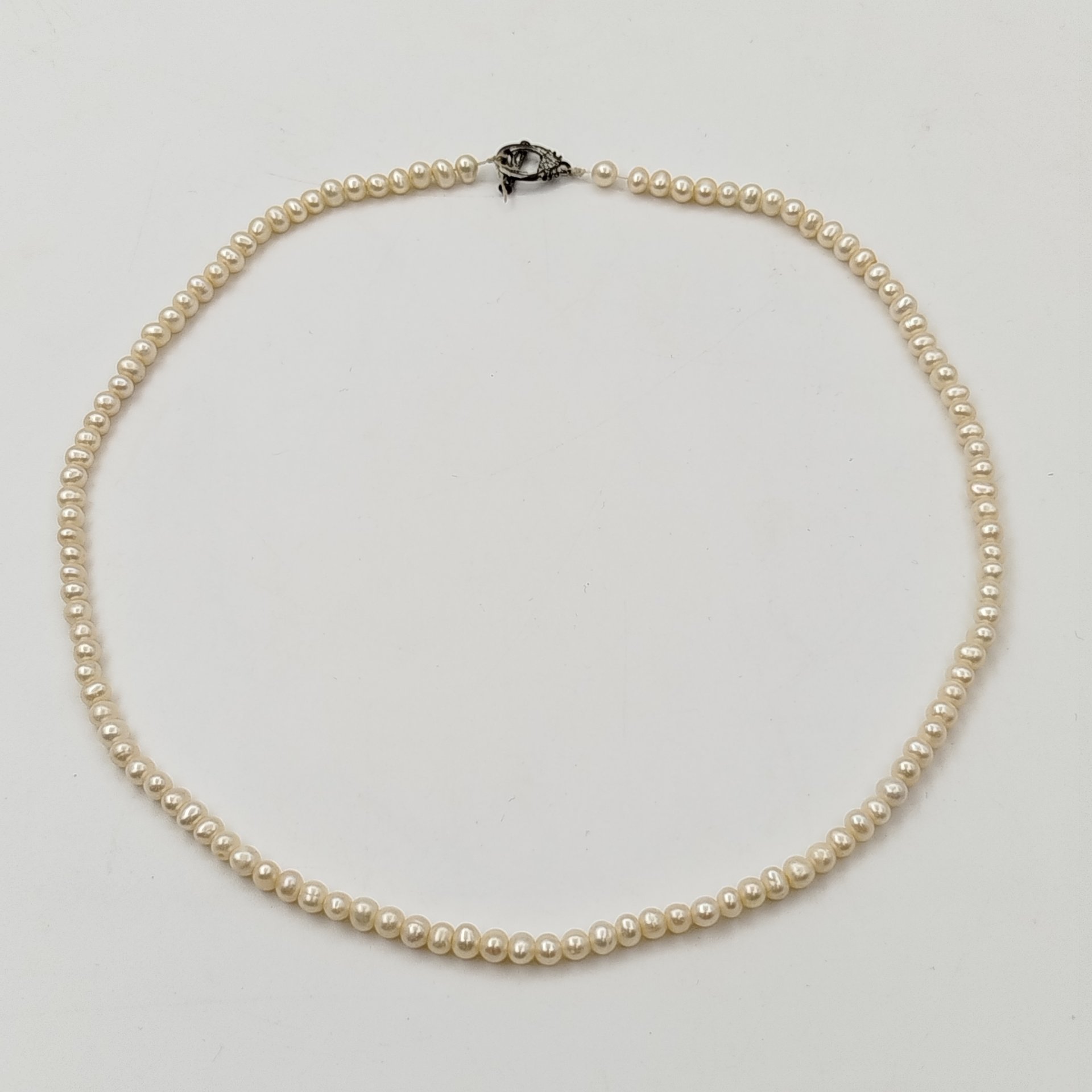 Бусы с мелкими круглыми бусинами и фигурной застежкой