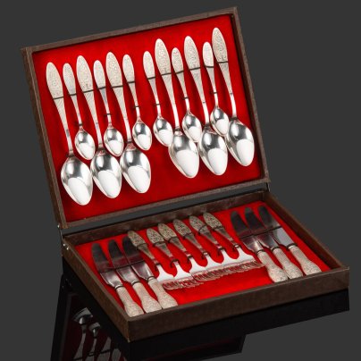 Набор столовых приборов на 6 персон, украшенных растительным декором, в коробке (28 предметов), мНЦ (медь-никель-цинк), картон, ткань, Режевский механический завод (РМ), СССР, 1970-1990 гг.