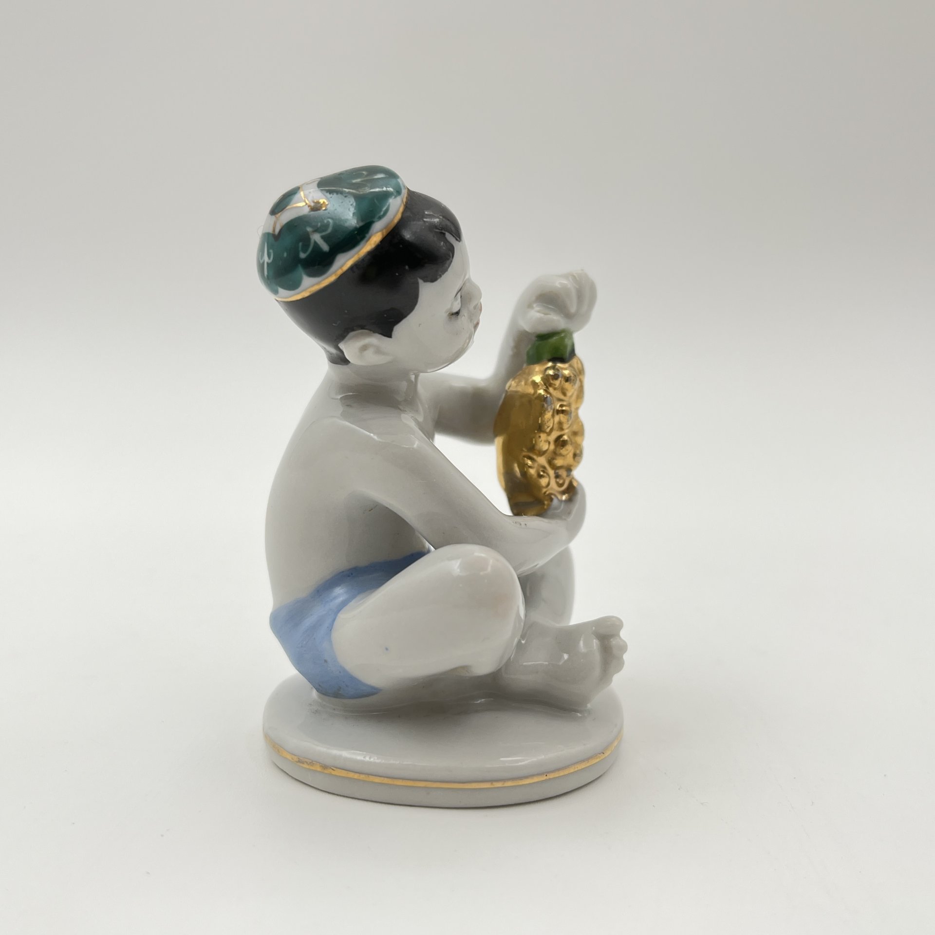 Статуэтка "Мальчик с виноградом" из серии "Счастливое детство", скульптор Г.С. Столбова, художник Е.Н. Лупанова, фарфор, роспись, золочение, Ленинградский фарфоровый завод (ЛФЗ), СССР, 1960-1970 гг.