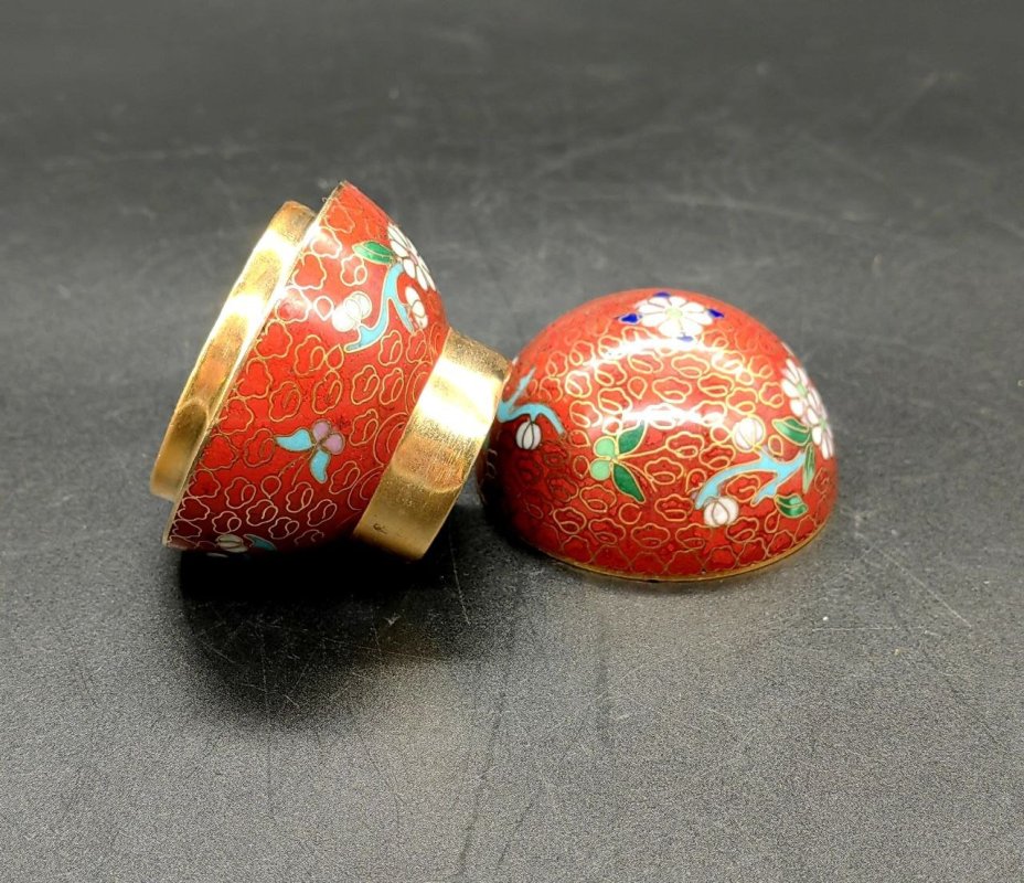 Шкатулка круглой формы с цветочным декором в технике клуазоне на красном фоне