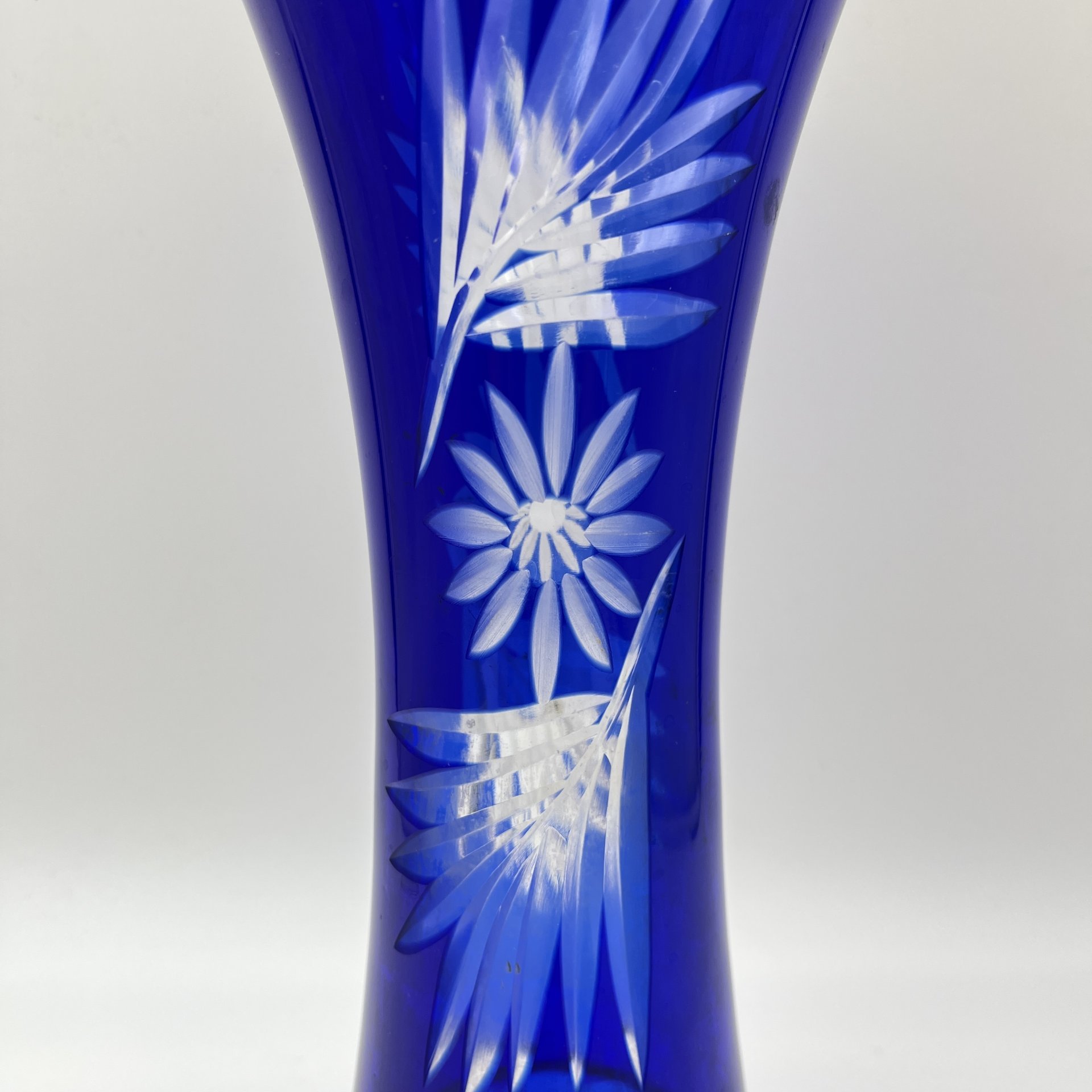 Ваза синего оттенка, украшенная цветочным декором