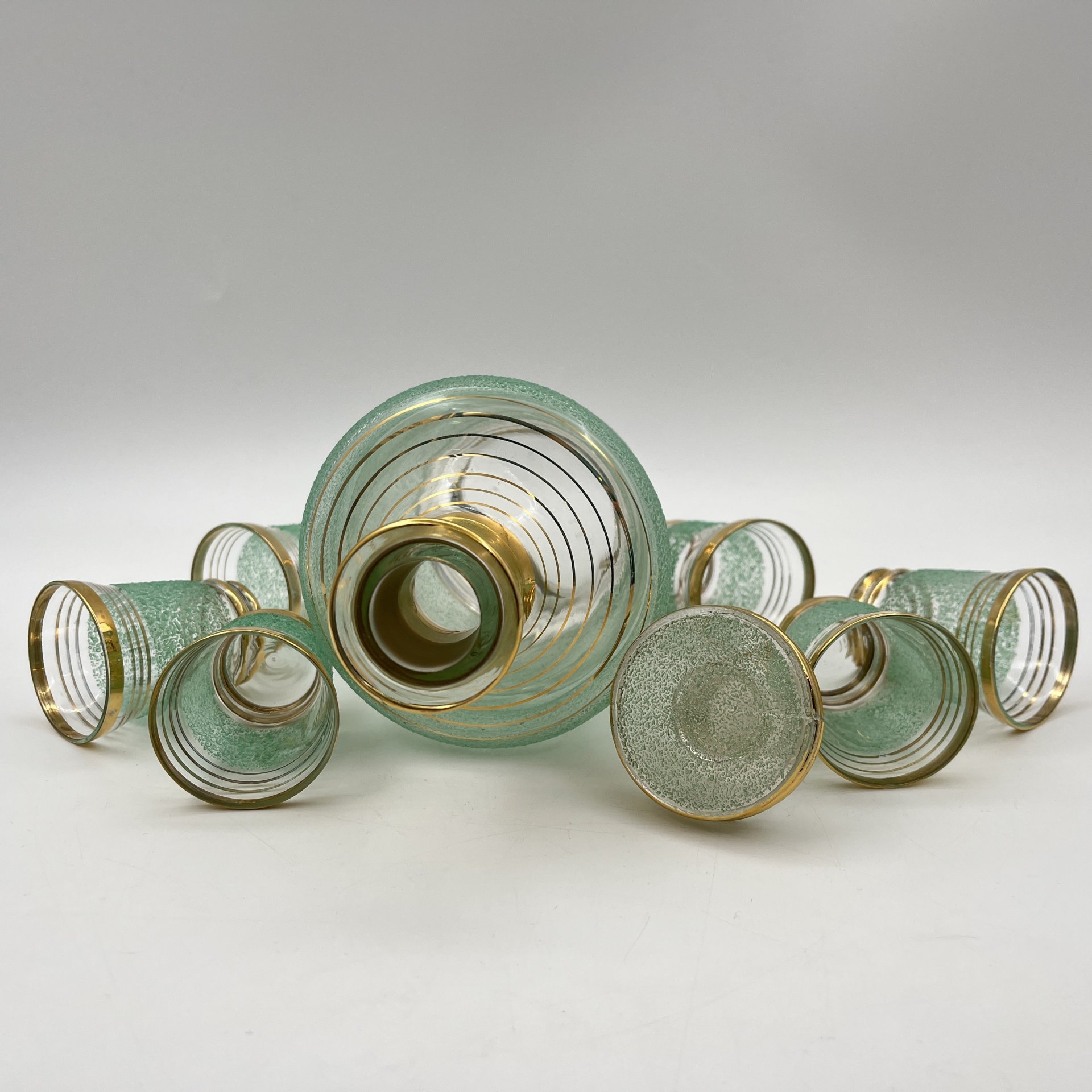 Набор для подачи крепких напитков на 6 персон (штоф и рюмки), декорированный обсыпкой из стеклянной крошки зелёного цвета, автор Н.А. Воинов, цветное стекло, золочение, Завод «Красный Гигант», СССР, 1960-1980 гг.