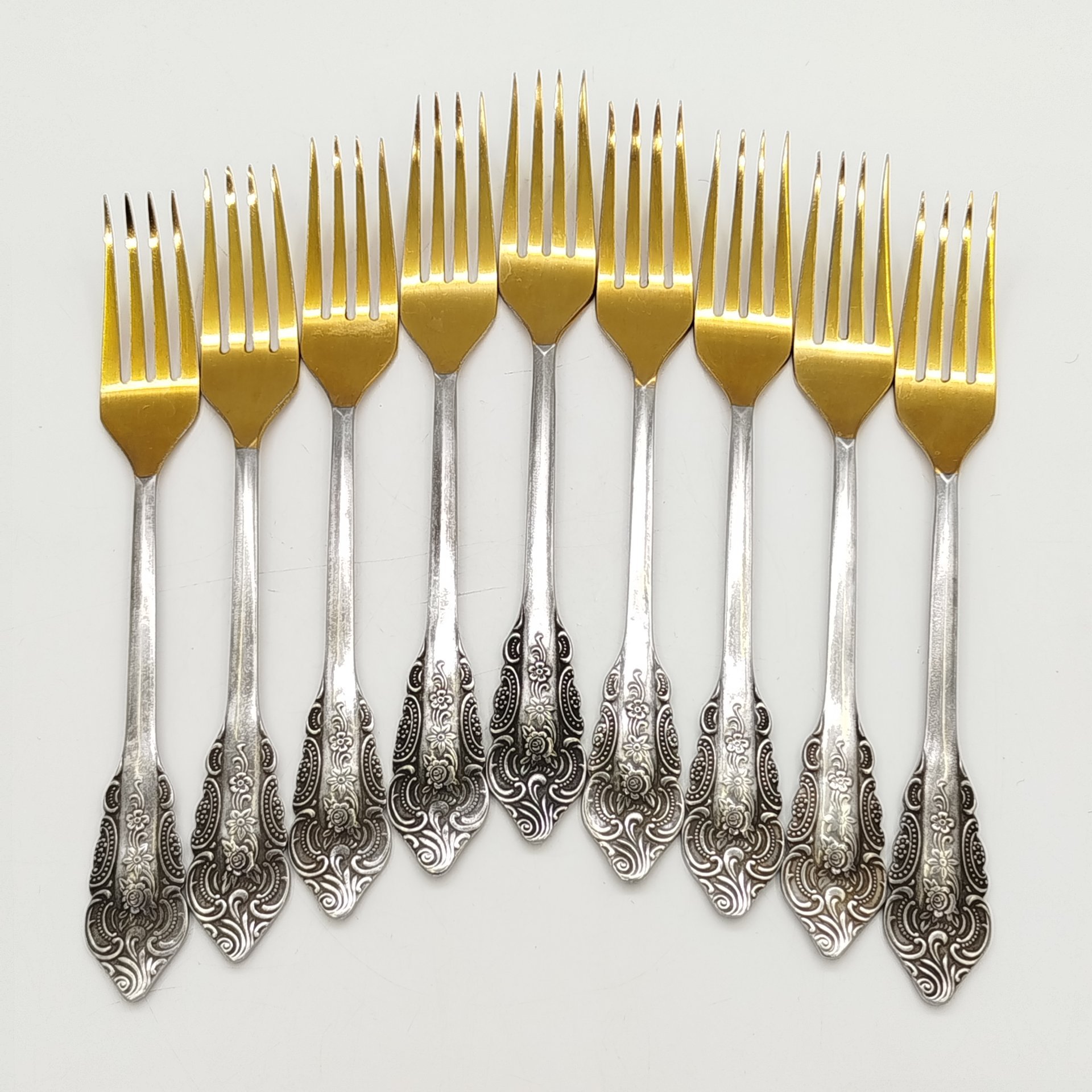 Набор из 9-ти столовых вилок, украшенных растительным декором, нержавеющая сталь, золочение, Павловский завод художественных металлоизделий им. С.М. Кирова, СССР
