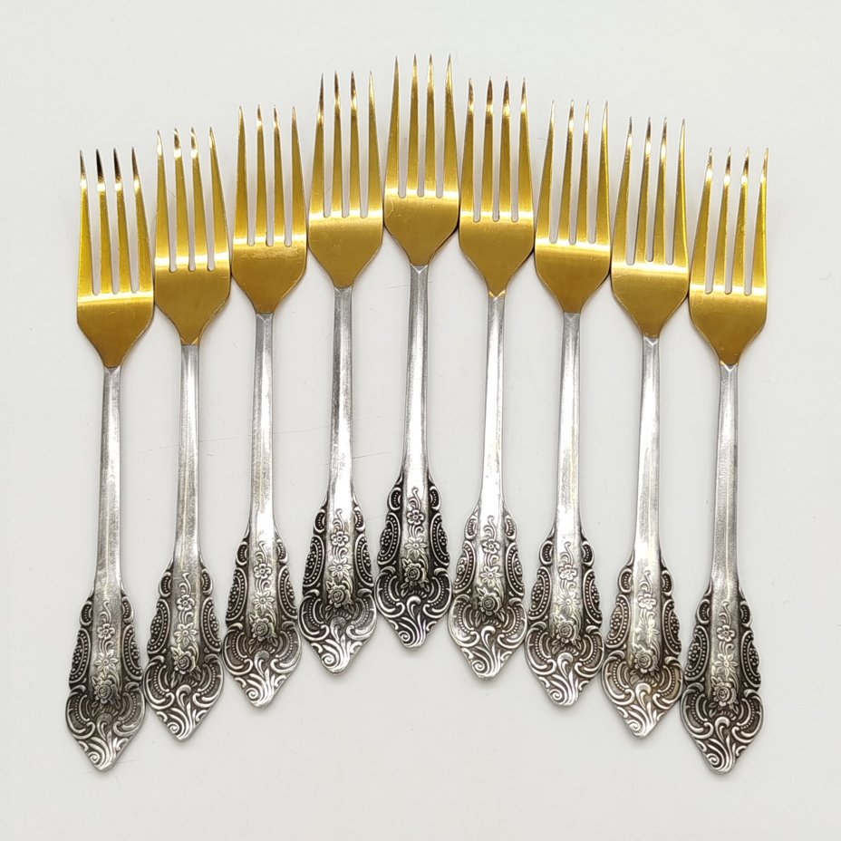 Набор из 9-ти столовых вилок, украшенных растительным декором, нержавеющая сталь, золочение, Павловский завод художественных металлоизделий им. С.М. Кирова, СССР