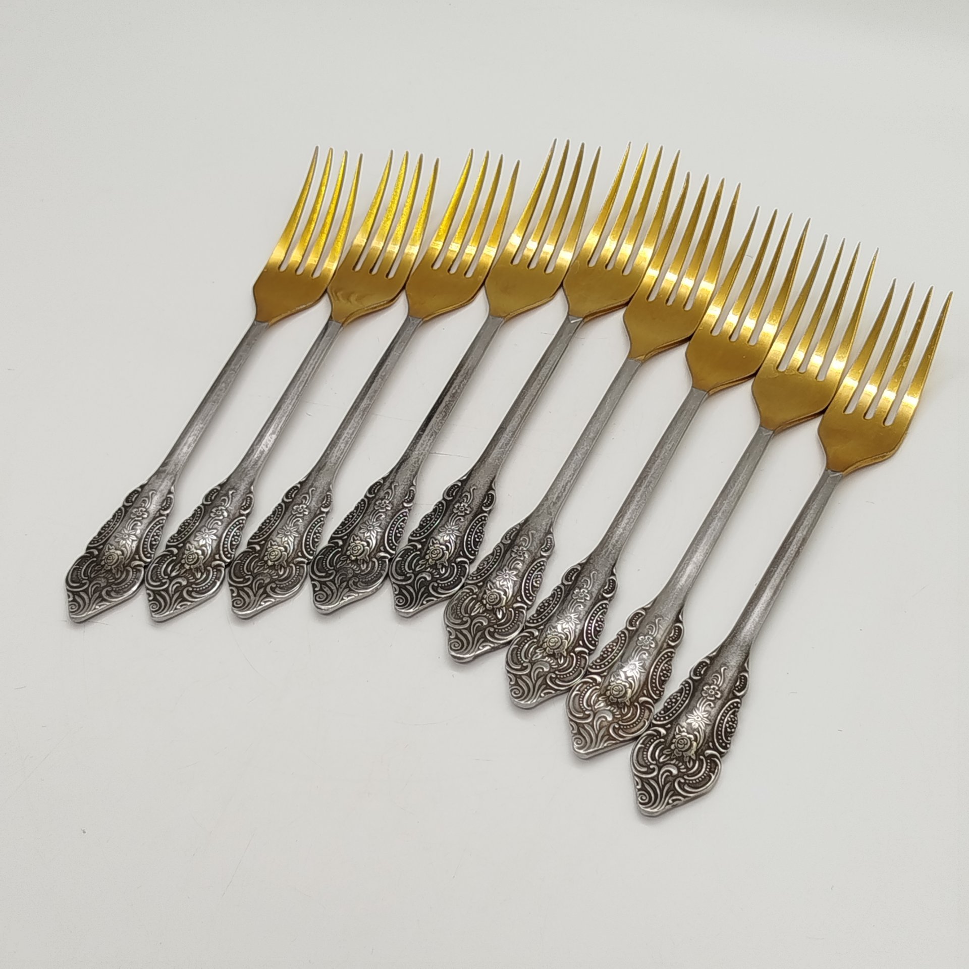 Набор из 9-ти столовых вилок, украшенных растительным декором, нержавеющая сталь, золочение, Павловский завод художественных металлоизделий им. С.М. Кирова, СССР