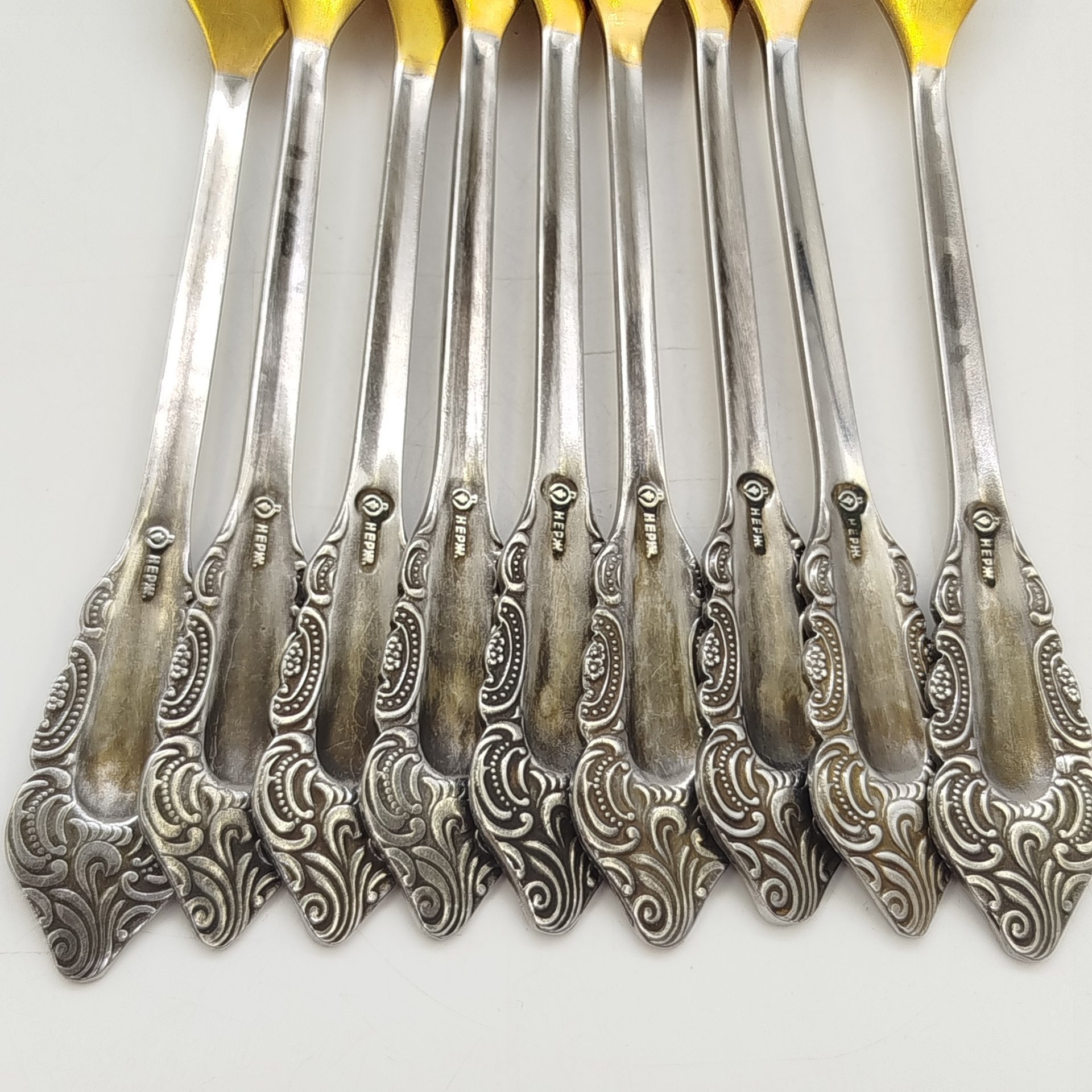 Набор из 9-ти столовых вилок, украшенных растительным декором, нержавеющая сталь, золочение, Павловский завод художественных металлоизделий им. С.М. Кирова, СССР