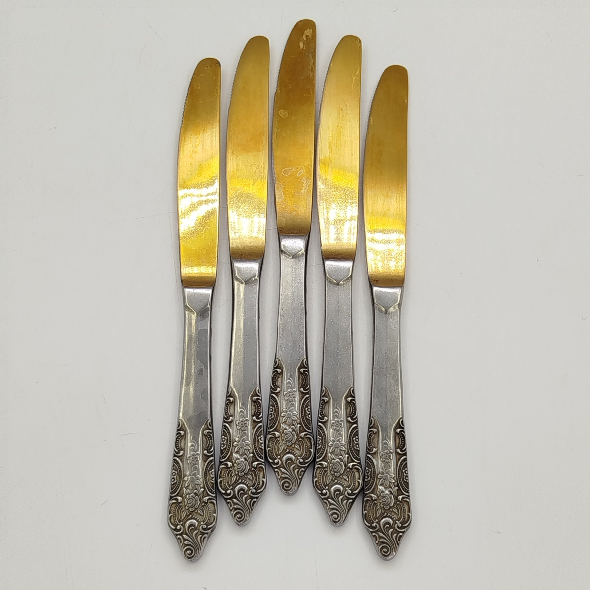 Набор из 5-ти столовых ножей, украшенных растительным декором, нержавеющая сталь, золочение, Павловский завод художественных металлоизделий им. С.М. Кирова, СССР