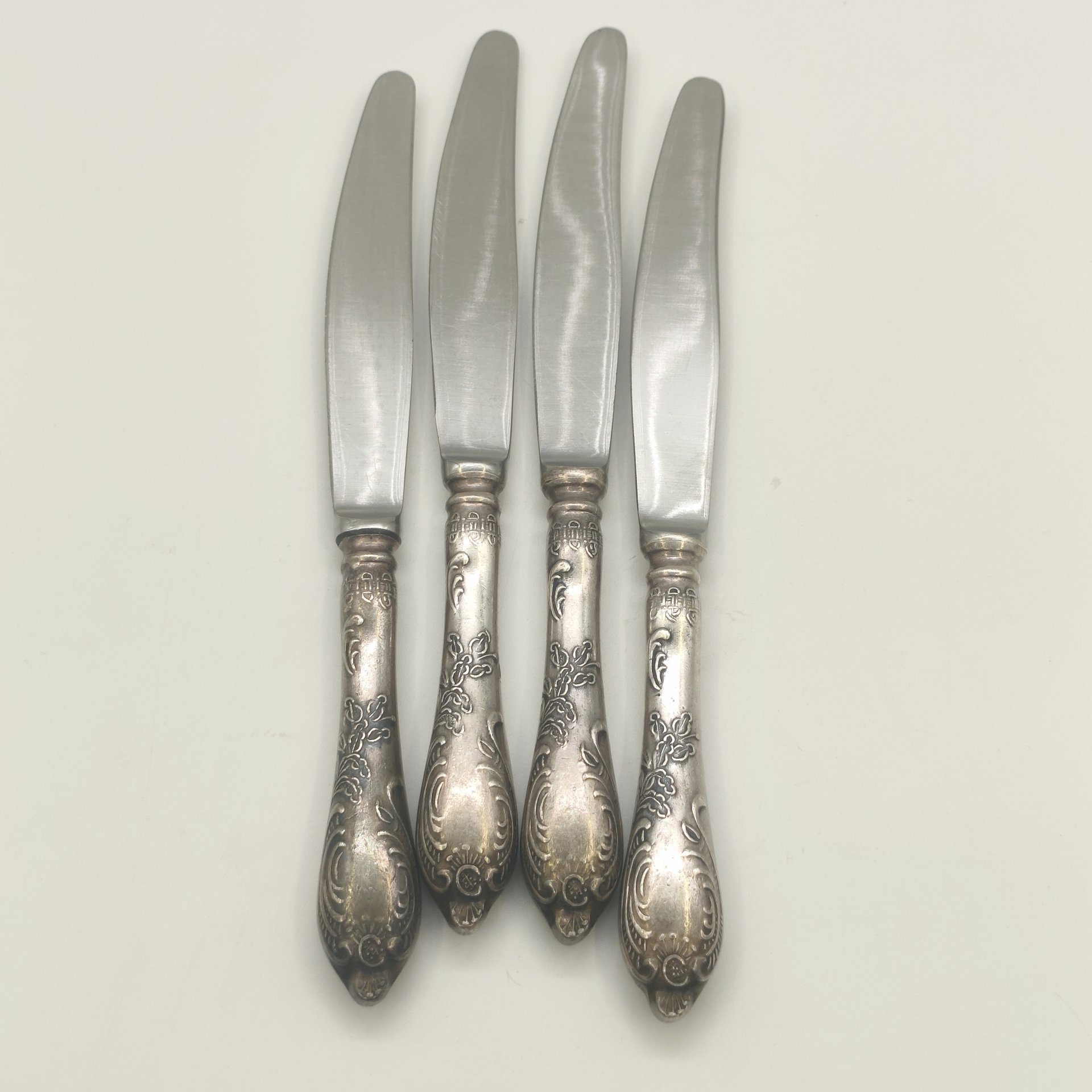 Набор из 4-х десертных ножей с растительным декором, мельхиор (медь-никель), нержавеющая сталь, Режевский механический завод (РМ), СССР, 1975-1983 гг.