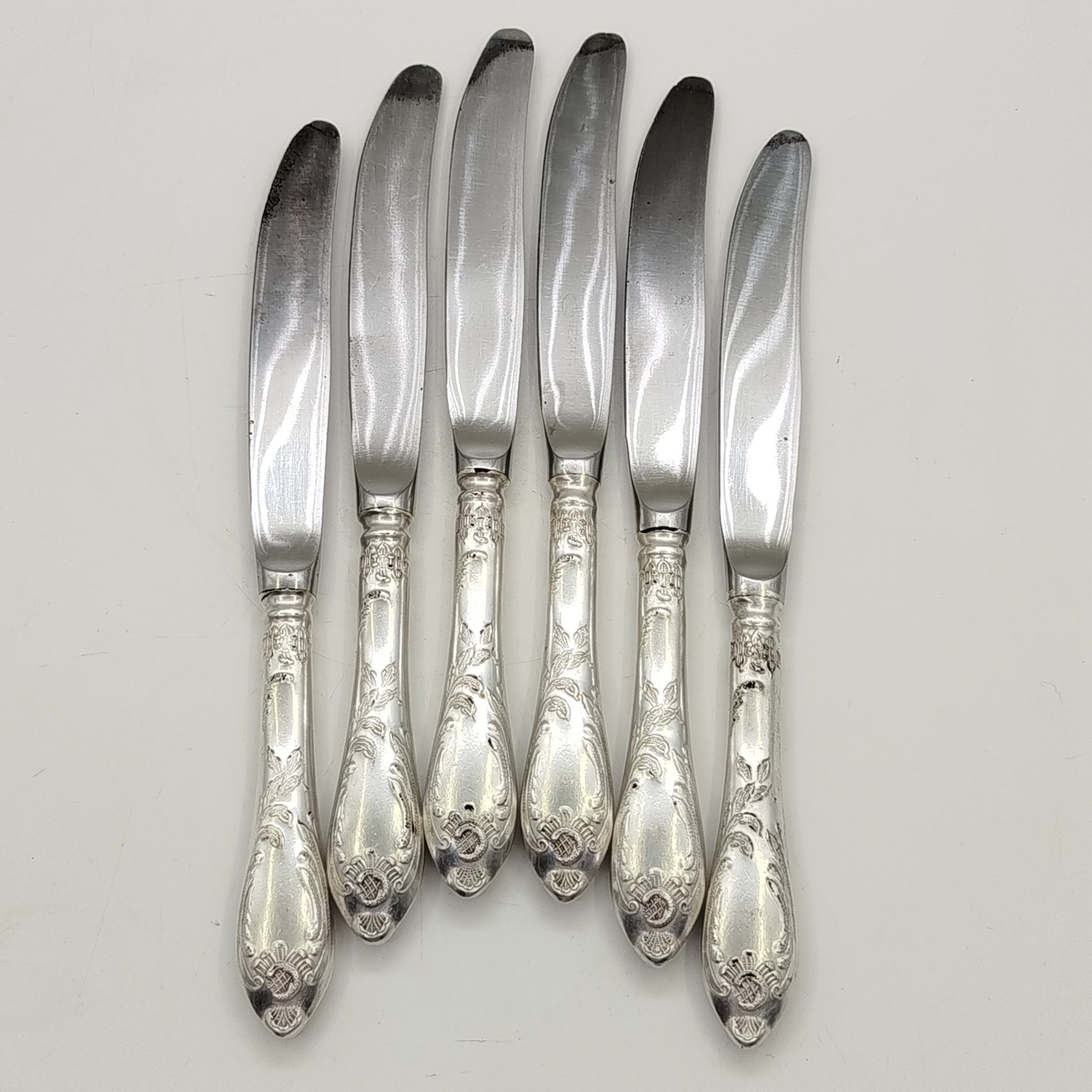 Набор из шести десертных ножей с растительным декором, мНЦ (медь-никель-цинк), сталь, Вольнянский завод столовых приборов им. Шевченко (ЗiШ, ЗиШ), СССР, 1960-1990 гг.