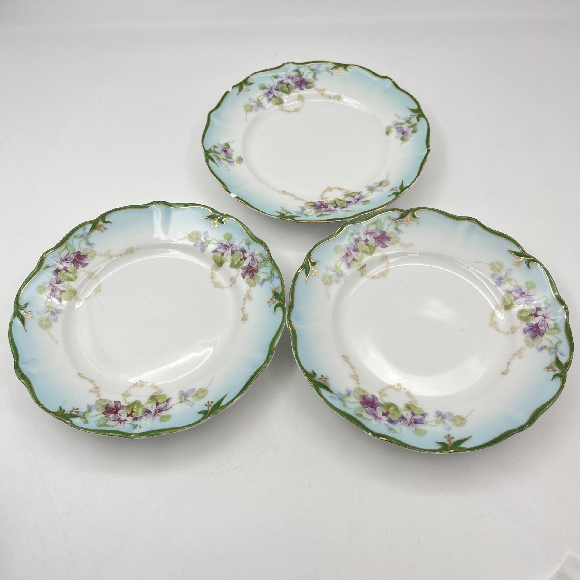 Набор из трех пирожковых тарелок с декором в виде сирени и зеленой каймой, фарфор, аэрография, деколь, обводка, золочение, подрисовка, Товарищество М.С. Кузнецова, Российская империя, 1890-1910 гг.
