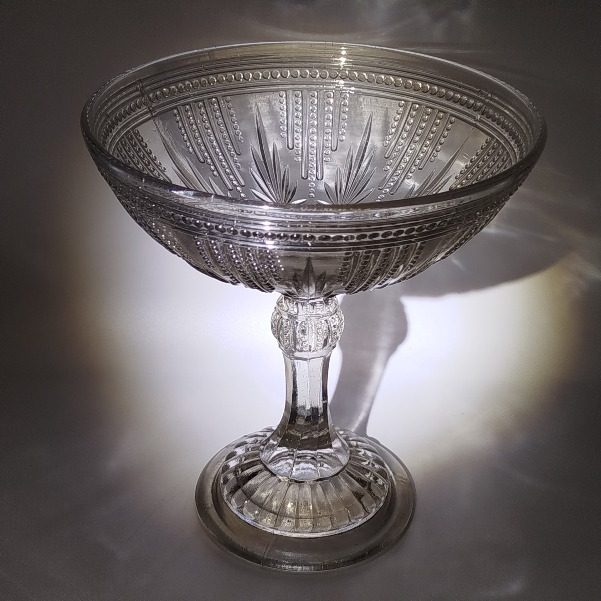 Фруктовница на высокой граненой ножке с рельефным декором на чаше