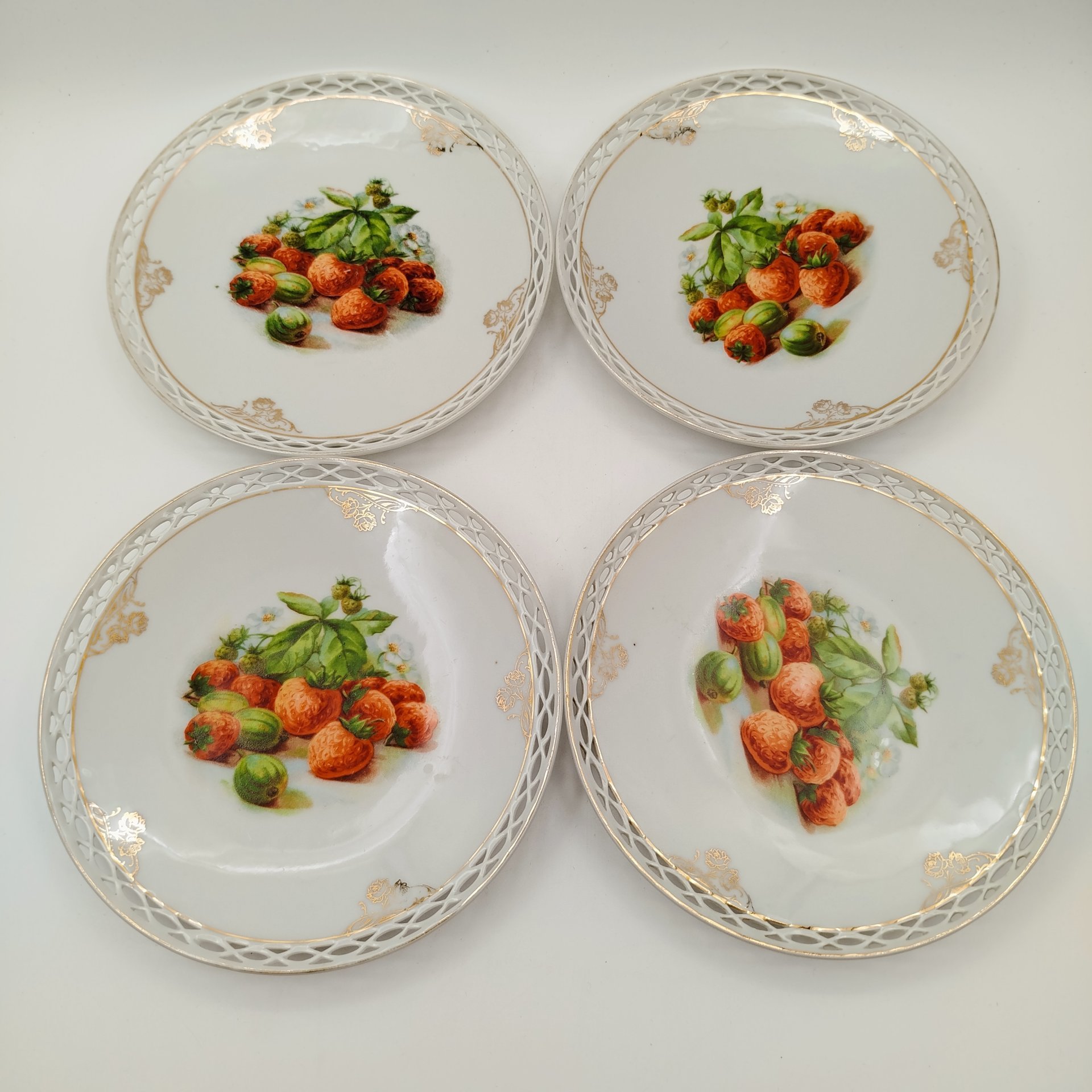 Набор десертных тарелок с прорезным бортом "Ягоды и фрукты" на 4 персоны, фарфор, деколь, золочение, Западная Европа, 1900-1930 гг.