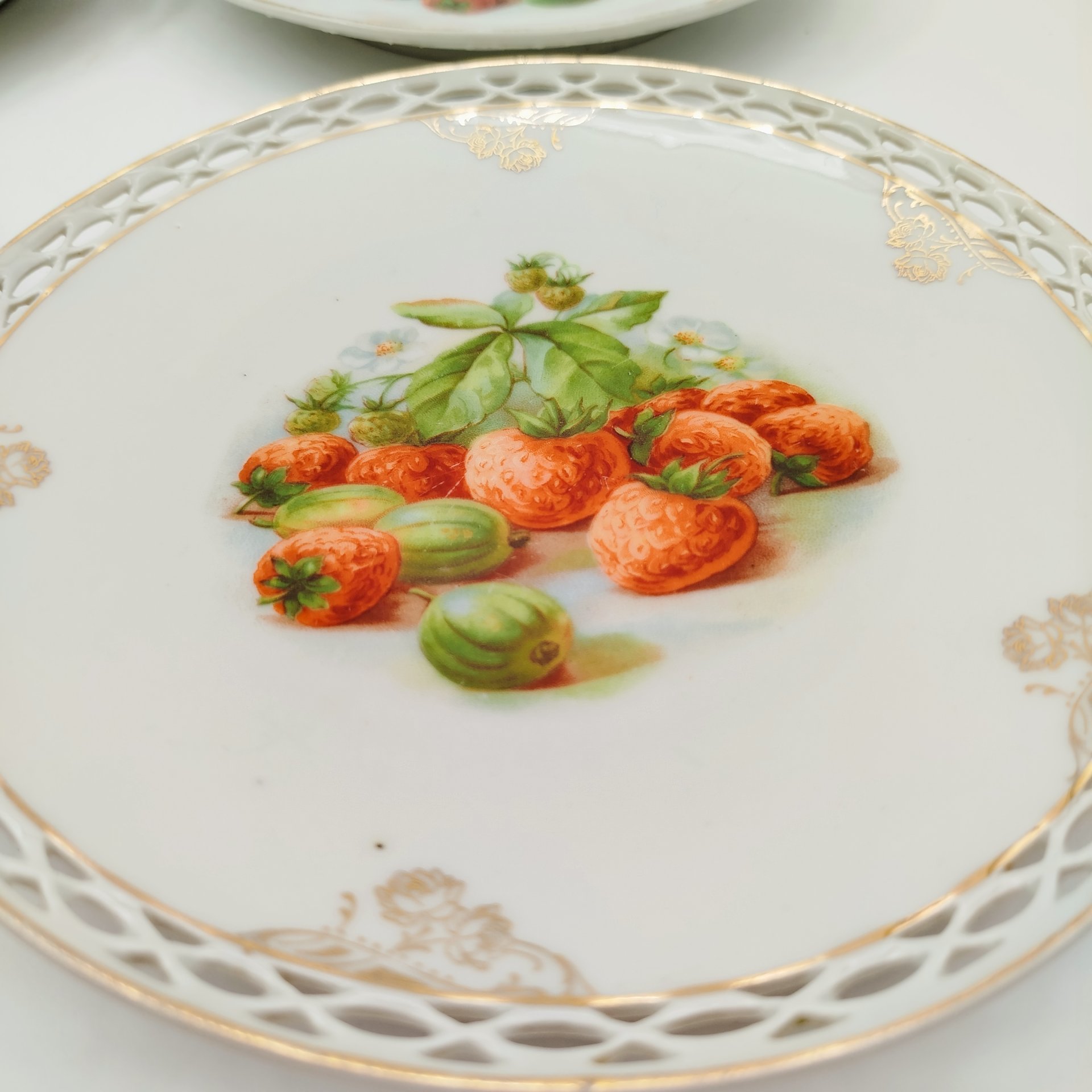 Набор десертных тарелок с прорезным бортом "Ягоды и фрукты" на 4 персоны, фарфор, деколь, золочение, Западная Европа, 1900-1930 гг.