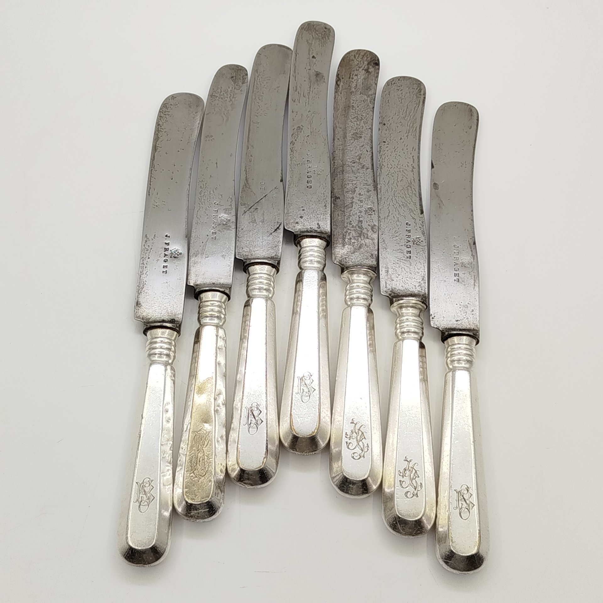 Набор из семи столовых ножей с гранеными рукоятями и владельческими монограммами, металл, серебрение, сталь, Fraget (Фабрика серебряных и плакированных изделий Иосифа Фраже), Царство Польское, 1890-1915 гг.