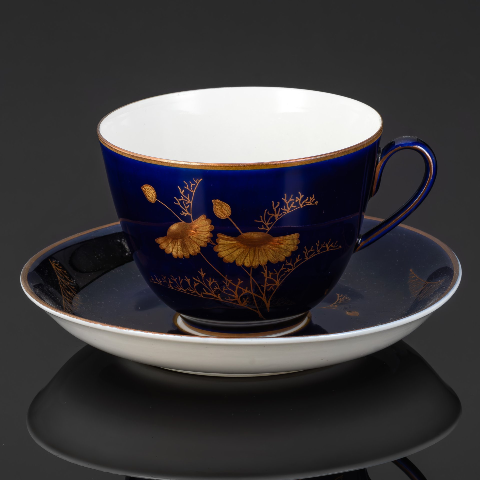 Пара чайная с декором в виде золотых ромашек, автор формы Яковлева С.Е., автор рисунка Лебединская Л.И. (предположительно), фарфор, крытье кобальтом, золочение, Ленинградский фарфоровый завод (ЛФЗ), СССР, 1950-1970 гг.