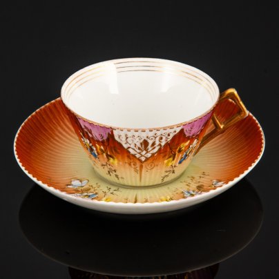 Пара чайная формы "французской рамкой ручка" с декором в виде ромашек на градиентном жёлто-охристом фоне, фарфор, роспись, крытье, золочение, Фабрика И.Е. Кузнецова на Волхове, Российская империя, 1900-1917 гг.