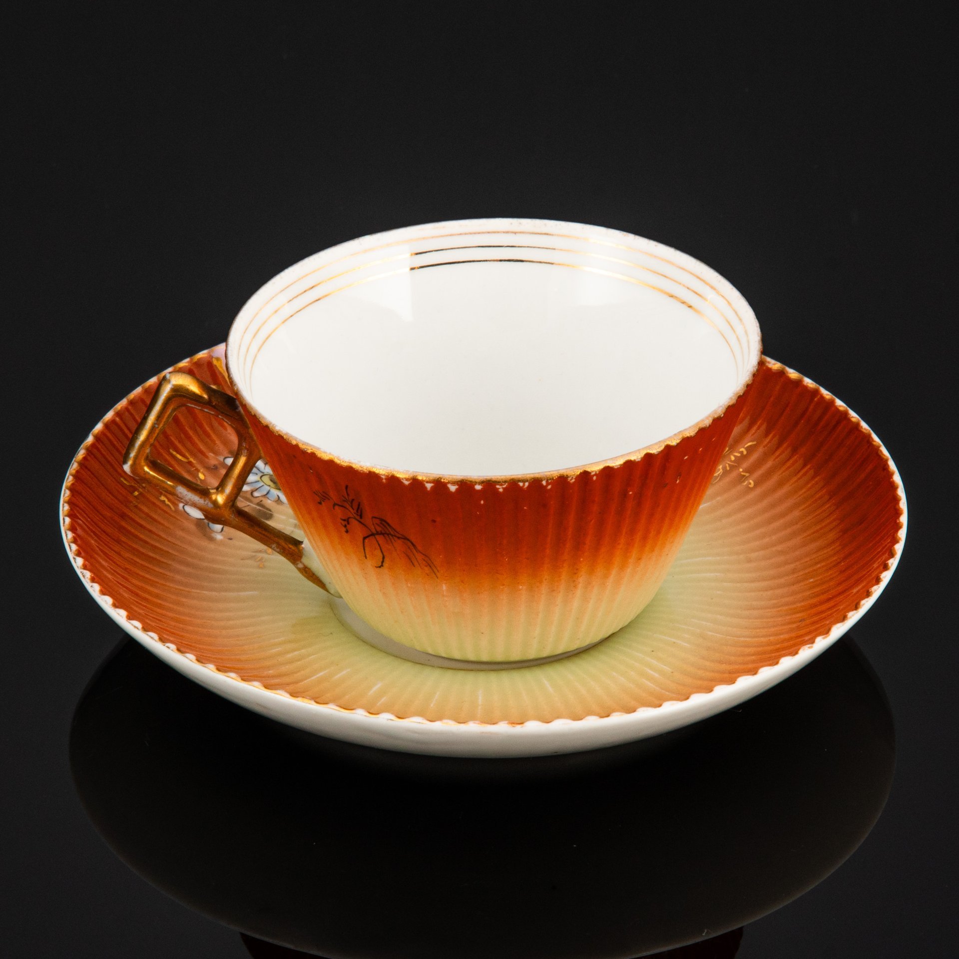 Пара чайная формы "французской рамкой ручка" с декором в виде ромашек на градиентном жёлто-охристом фоне, фарфор, роспись, крытье, золочение, Фабрика И.Е. Кузнецова на Волхове, Российская империя, 1900-1917 гг.