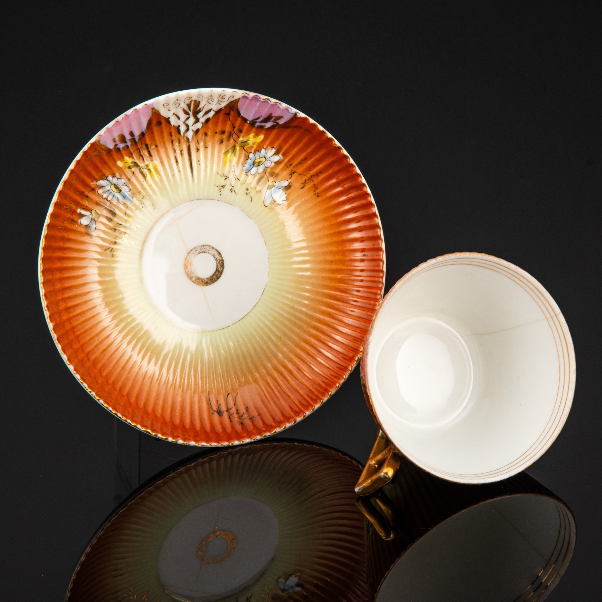 Пара чайная формы "французской рамкой ручка" с декором в виде ромашек на градиентном жёлто-охристом фоне, фарфор, роспись, крытье, золочение, Фабрика И.Е. Кузнецова на Волхове, Российская империя, 1900-1917 гг.