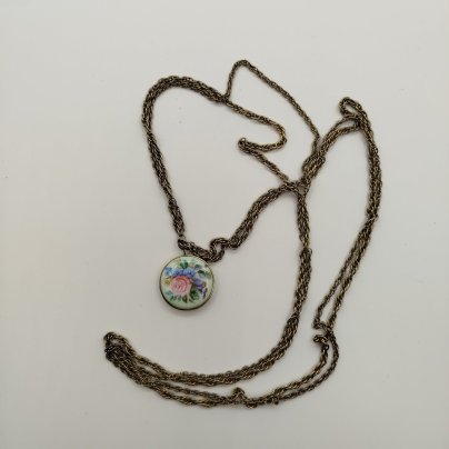 Медальон на цепочке украшенный цветочным декором