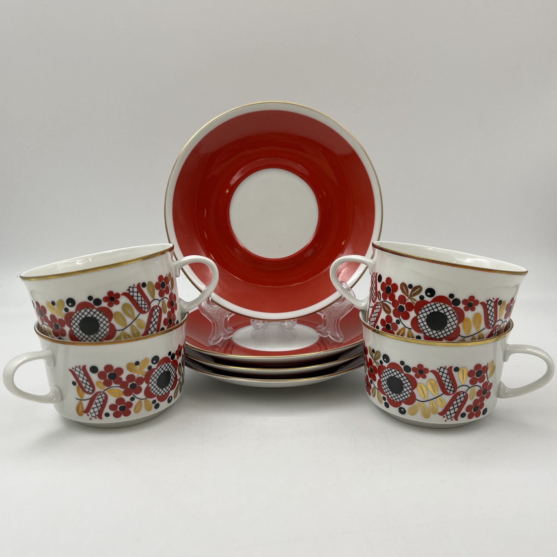 Набор чайных пар на 4 персоны, выполненных в ярко-красном цвете с флористическим декором, фарфор, крытье, деколь, золочение, Freiberger Porzellan, ГДР, 1970-1990 гг.