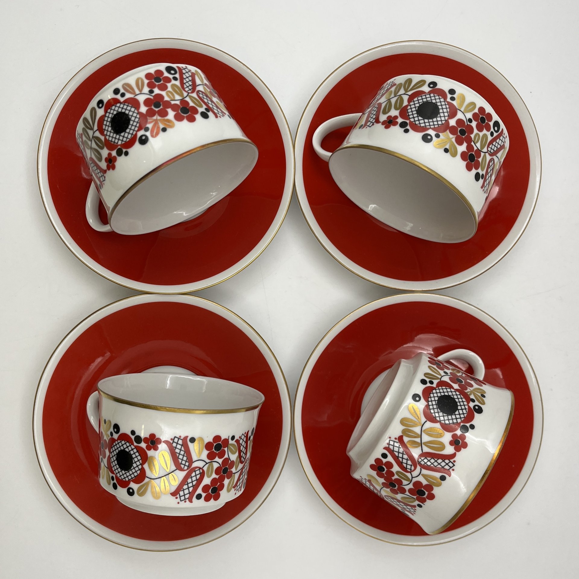 Набор чайных пар на 4 персоны, выполненных в ярко-красном цвете с флористическим декором, фарфор, крытье, деколь, золочение, Freiberger Porzellan, ГДР, 1970-1990 гг.