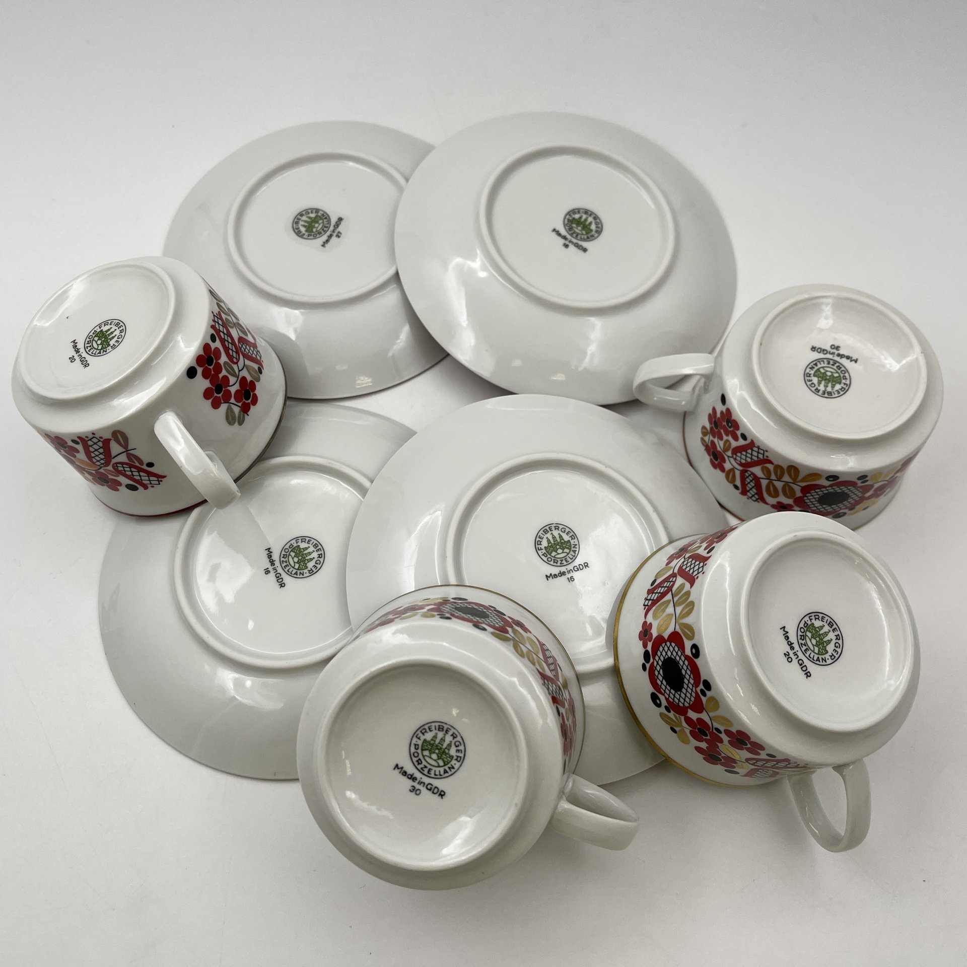 Набор чайных пар на 4 персоны, выполненных в ярко-красном цвете с флористическим декором, фарфор, крытье, деколь, золочение, Freiberger Porzellan, ГДР, 1970-1990 гг.