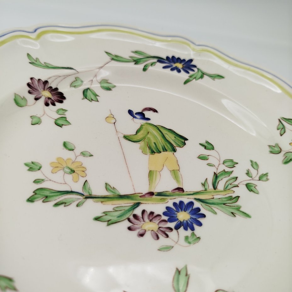 Тарелка обеденная, украшенная изображением цветов, бабочек и деревенского персонажа, узор "Moustiers", мануфактура "Longchamp"