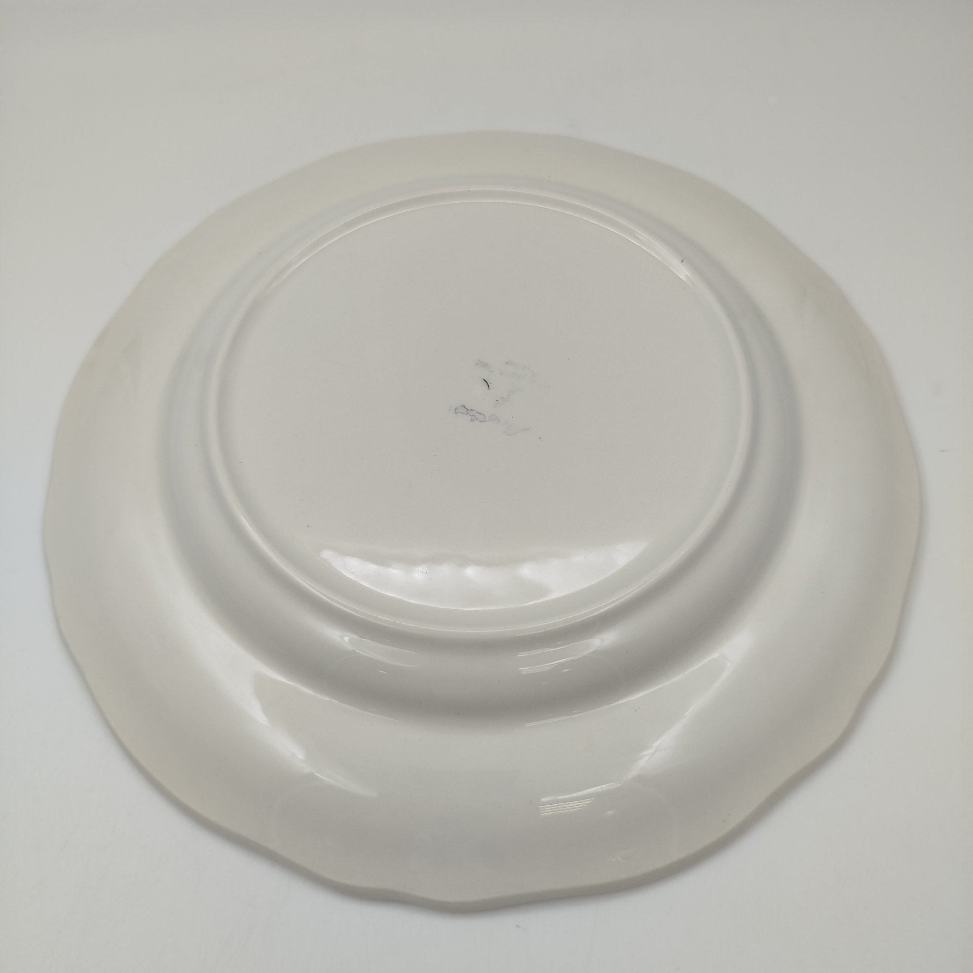 Тарелка обеденная, украшенная изображением цветов, бабочек и деревенского персонажа, узор "Moustiers", мануфактура "Longchamp", фаянс, деколь с подрисовкой, Франция, 1950-1970 гг.