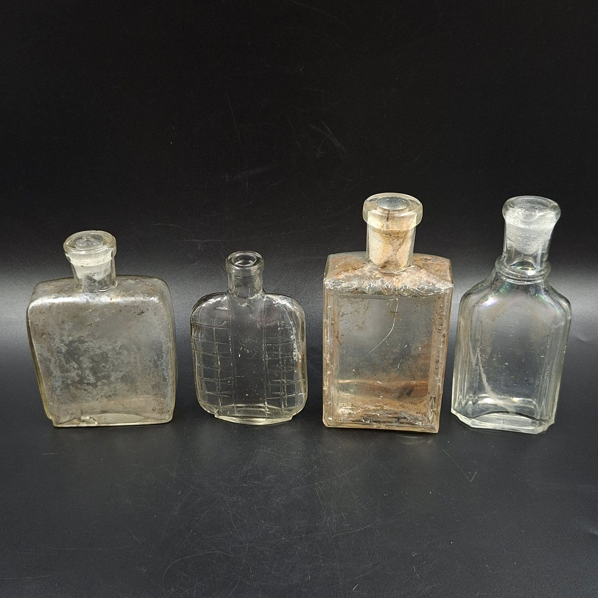 Набор из четырех уплощенных флаконов различных форм