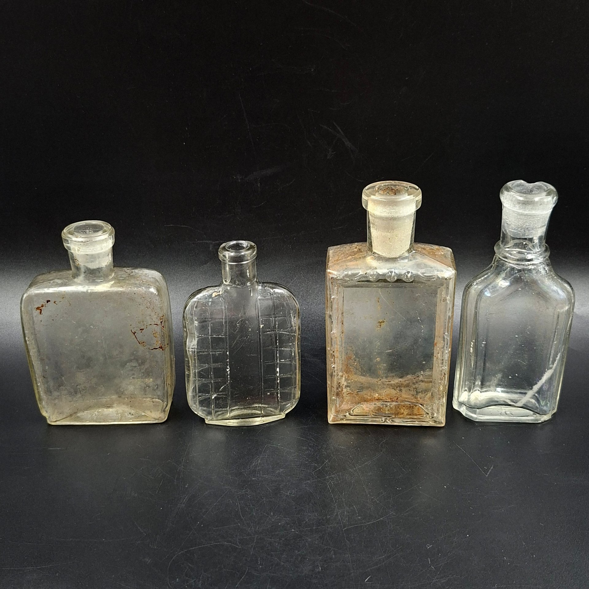 Набор из четырех уплощенных флаконов различных форм