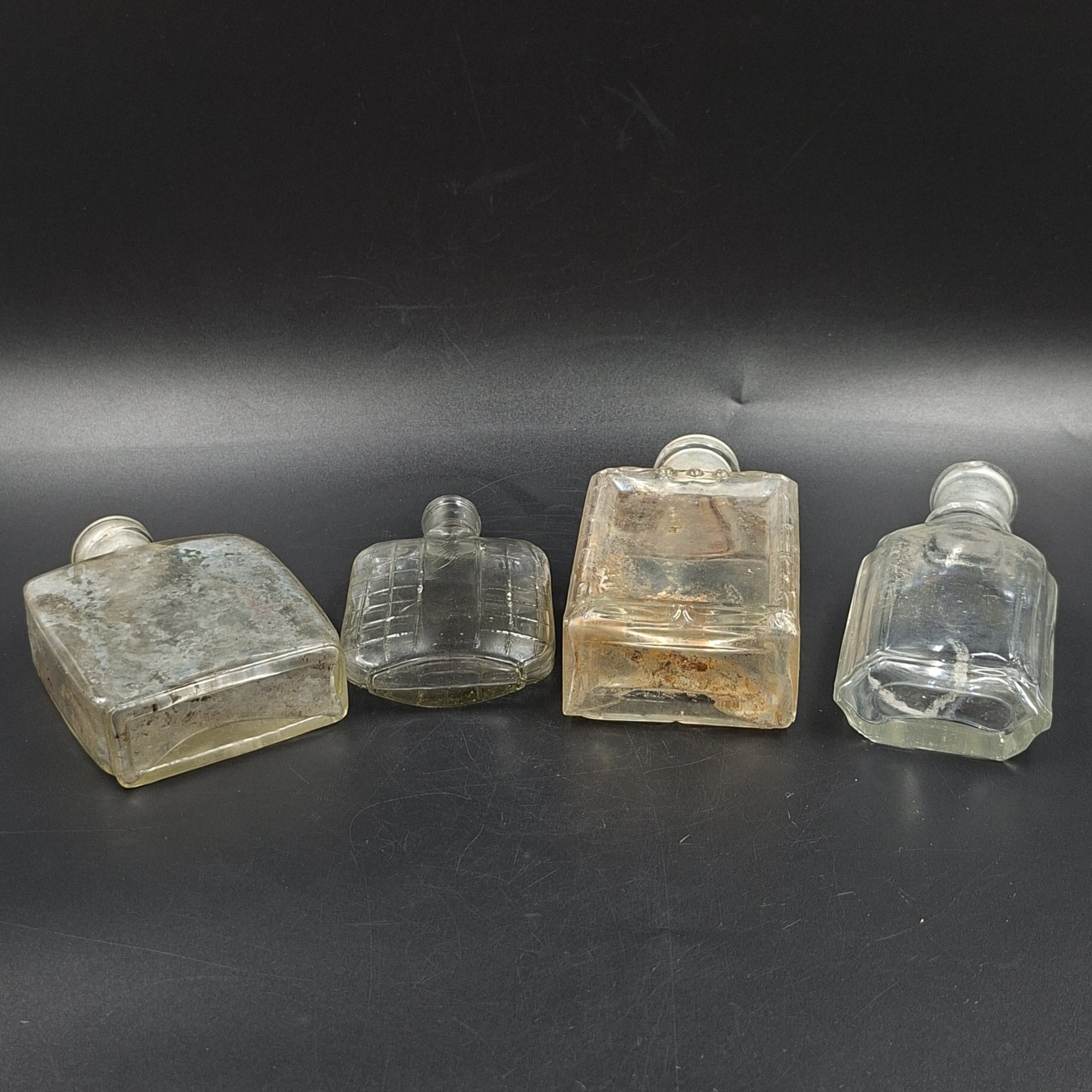 Набор из четырех уплощенных флаконов различных форм