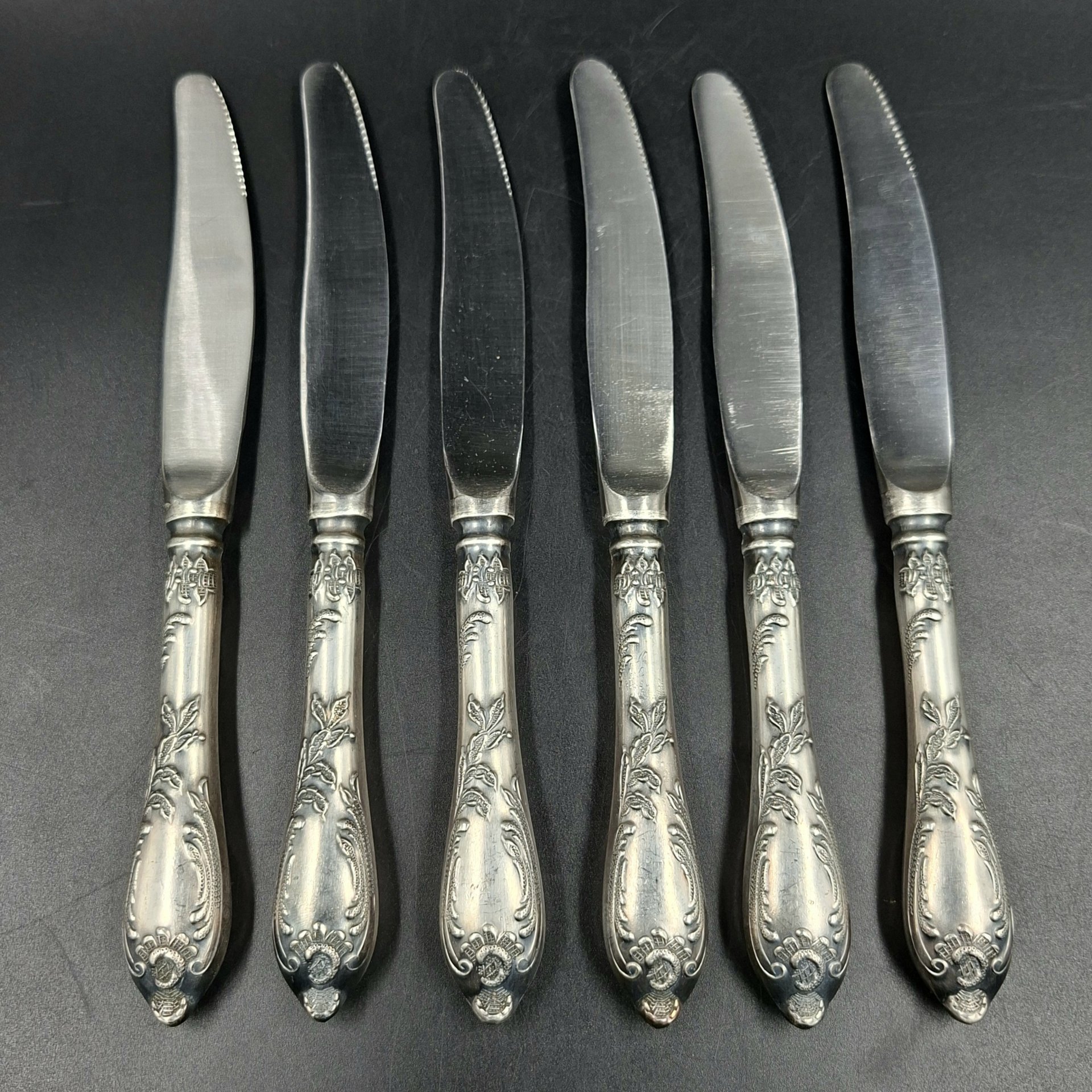 Набор из шести десертных ножей с растительным декором, мНЦ (медь-никель-цинк), сталь, Вольнянский завод столовых приборов им. Шевченко (ЗiШ, ЗиШ), СССР, 1960-1980 гг.