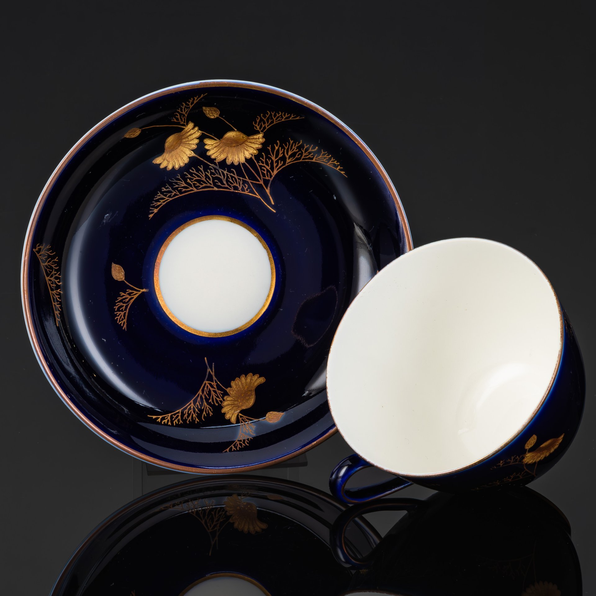 Пара чайная с декором в виде золотых ромашек, автор формы Яковлева С.Е., автор рисунка Лебединская Л.И. (предположительно), фарфор, крытье кобальтом, золочение, Ленинградский фарфоровый завод (ЛФЗ), СССР, 1950-1970 гг.