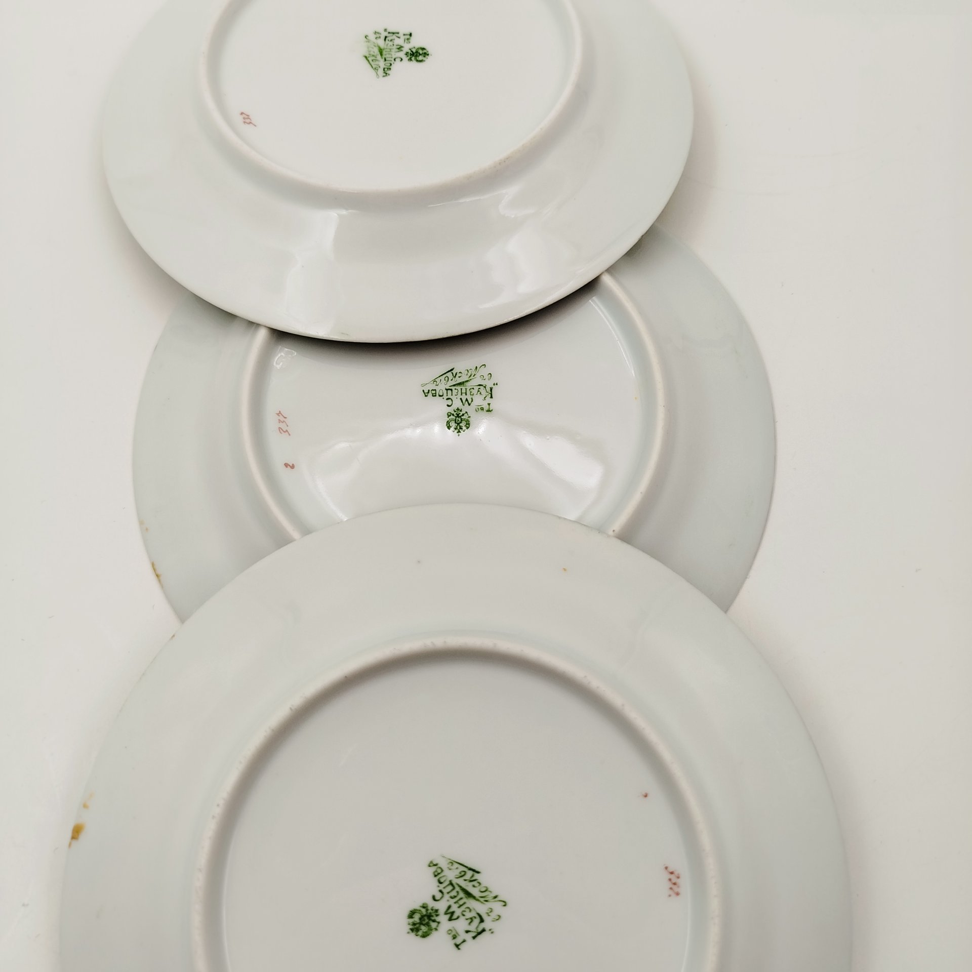 Набор из трех десертных тарелочек с зеленым бортом и изображением фруктов и цветов, фарфор, аэрография, деколь, подрисовка, золочение, Товарищество М.С. Кузнецова, Российская империя, 1880-1917 гг.