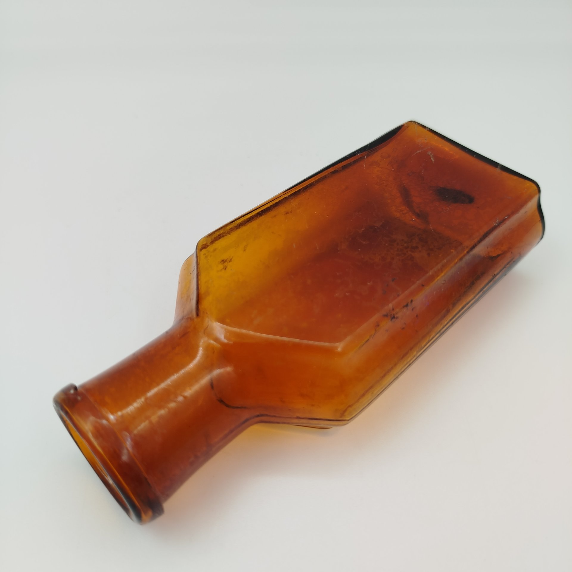 Флакон коричневого цвета с уплощенным туловом