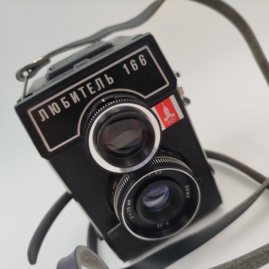 Фотоаппарат "Любитель-166" с олимпийской символикой в чехле, алюминий, искусственная кожа, стекло, бакелит, металл, ЛОМО (Ленинградское оптико-механическое объединение), СССР, 1976-1981 гг., ЛОМО (Ленинградское оптико-механическое объединение)
