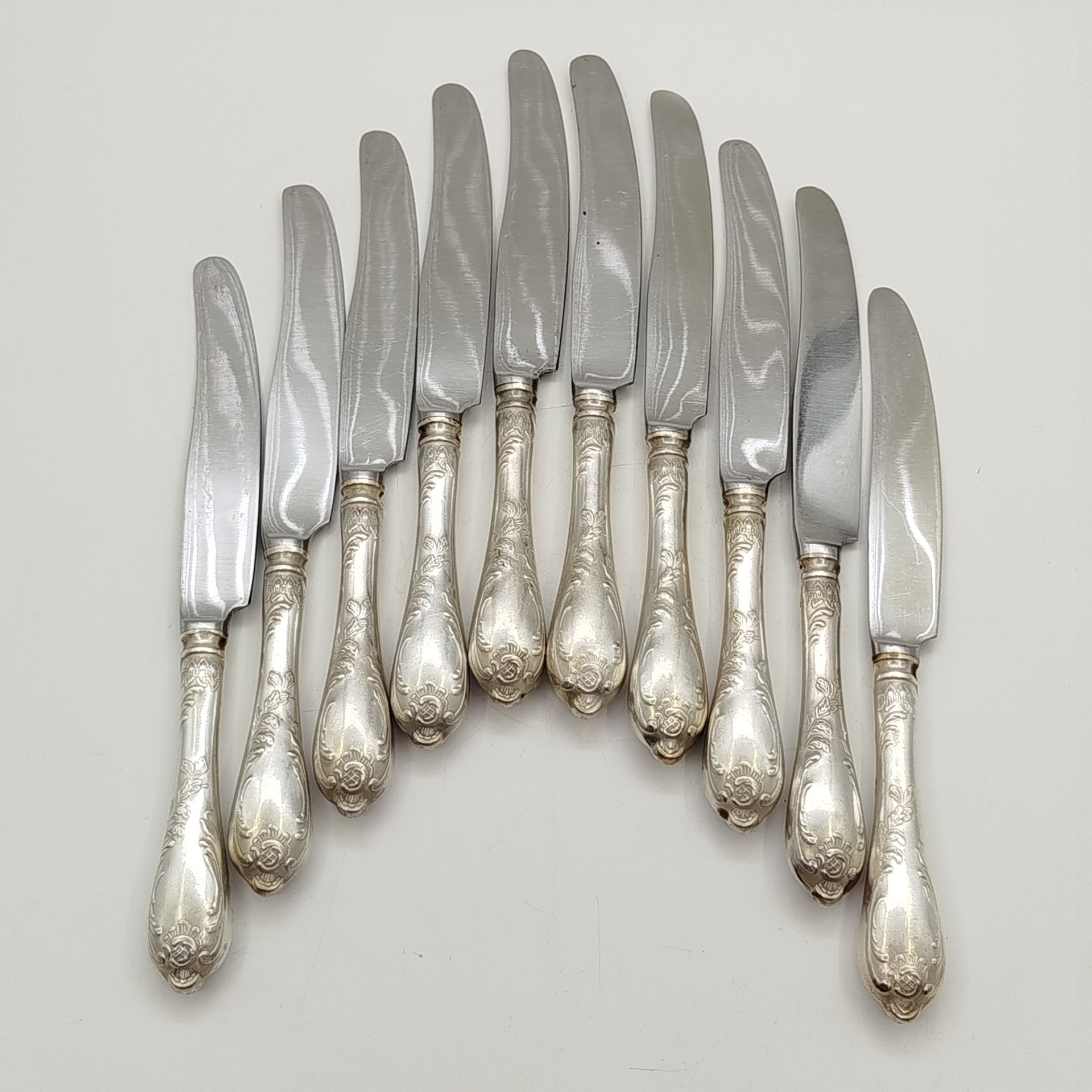 Набор из десяти десертных ножей с растительным декором, мНЦ (медь-никель-цинк), сталь, Вольнянский завод столовых приборов им. Шевченко (ЗiШ, ЗиШ), СССР, 1960-1990 гг.